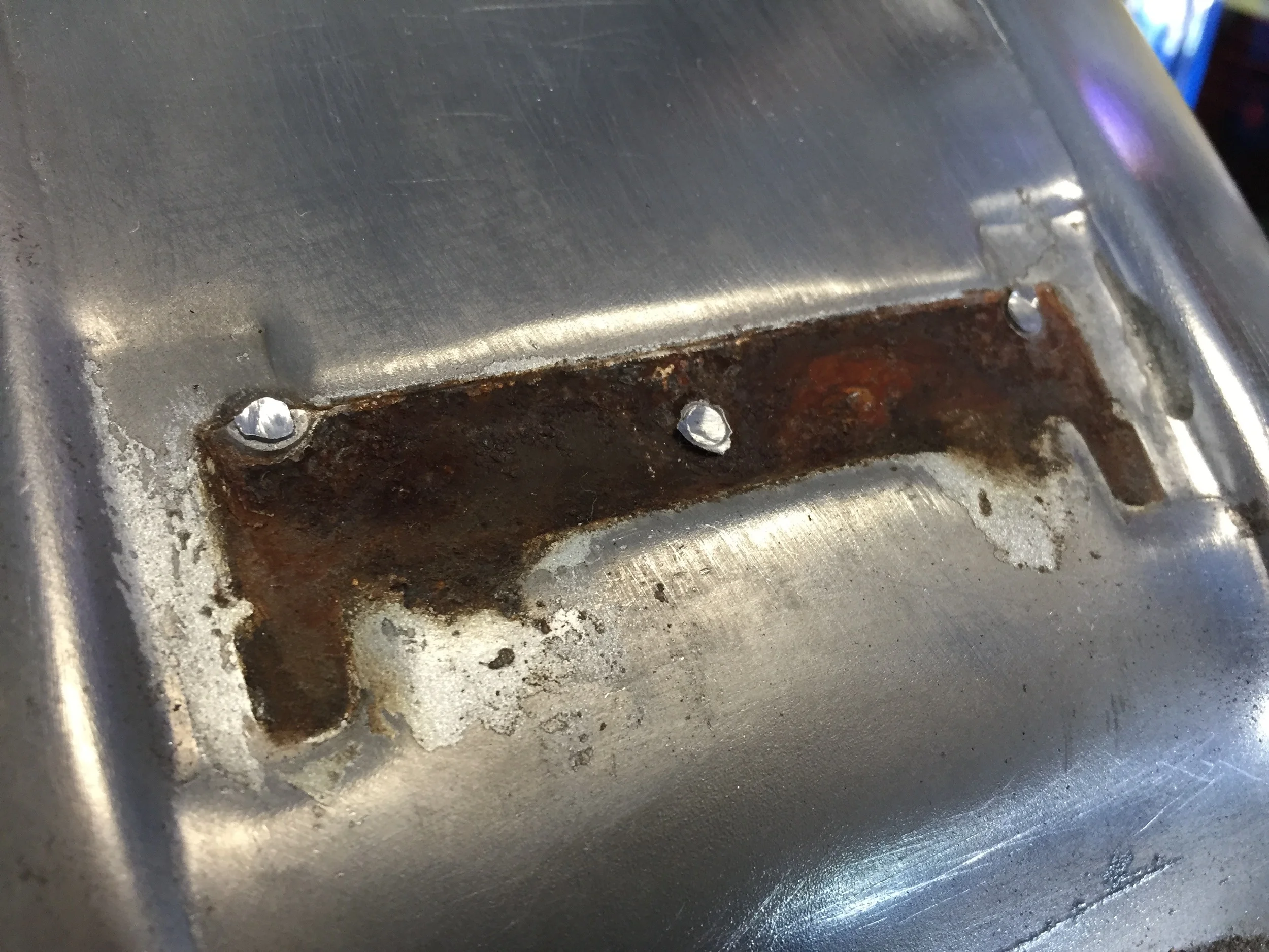 The gold tank that came on the bike was completely rotted. We had a little body work to do on the replacement tank so we decided to ditch the tabs and the rubber tank pad that came stock on the 200 tank.