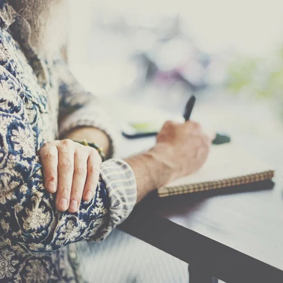 close-up of senior woman writing in spiral journal