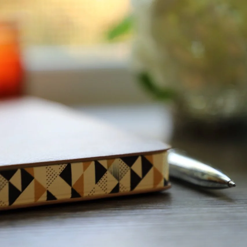 journal and pen softly lit by candle