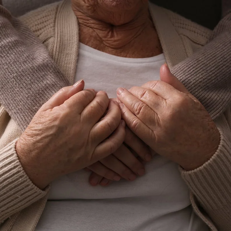 close-up of arms embracing a senior woman in hug