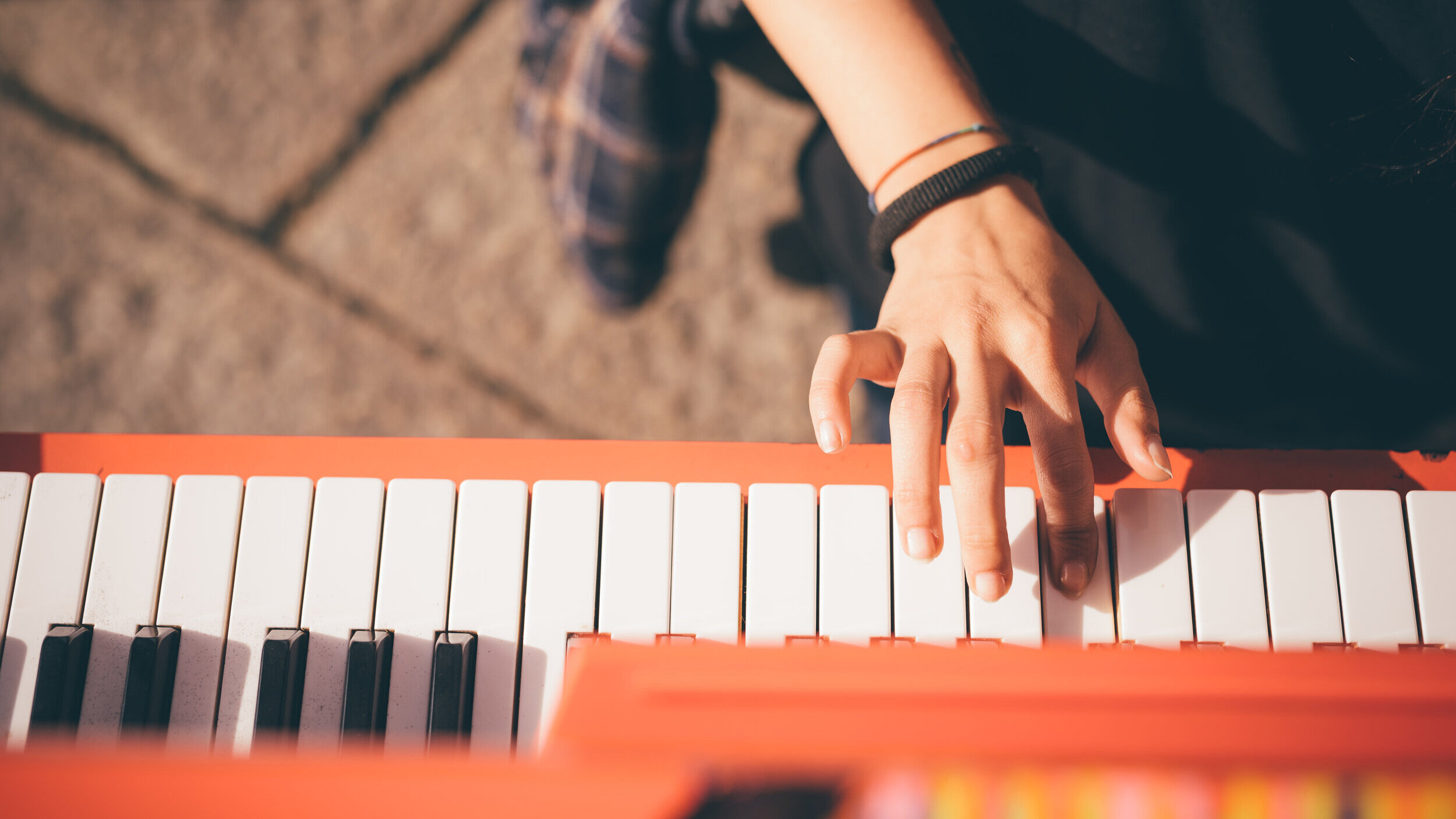 graphicstock-close-up-of-the-hand-of-young-woman-playing-piano-creative-performance-music-concept-she-is-dressed-with-a-black-shirt-and-plays-a-red-piano_raghnB7qk-.jpg