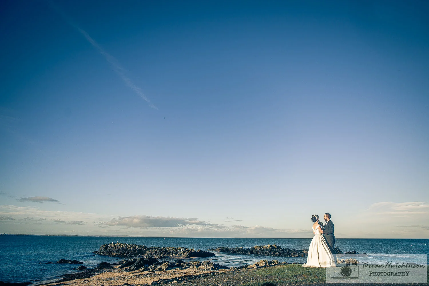 Bride and groom embrace by the sea at skerries dublin