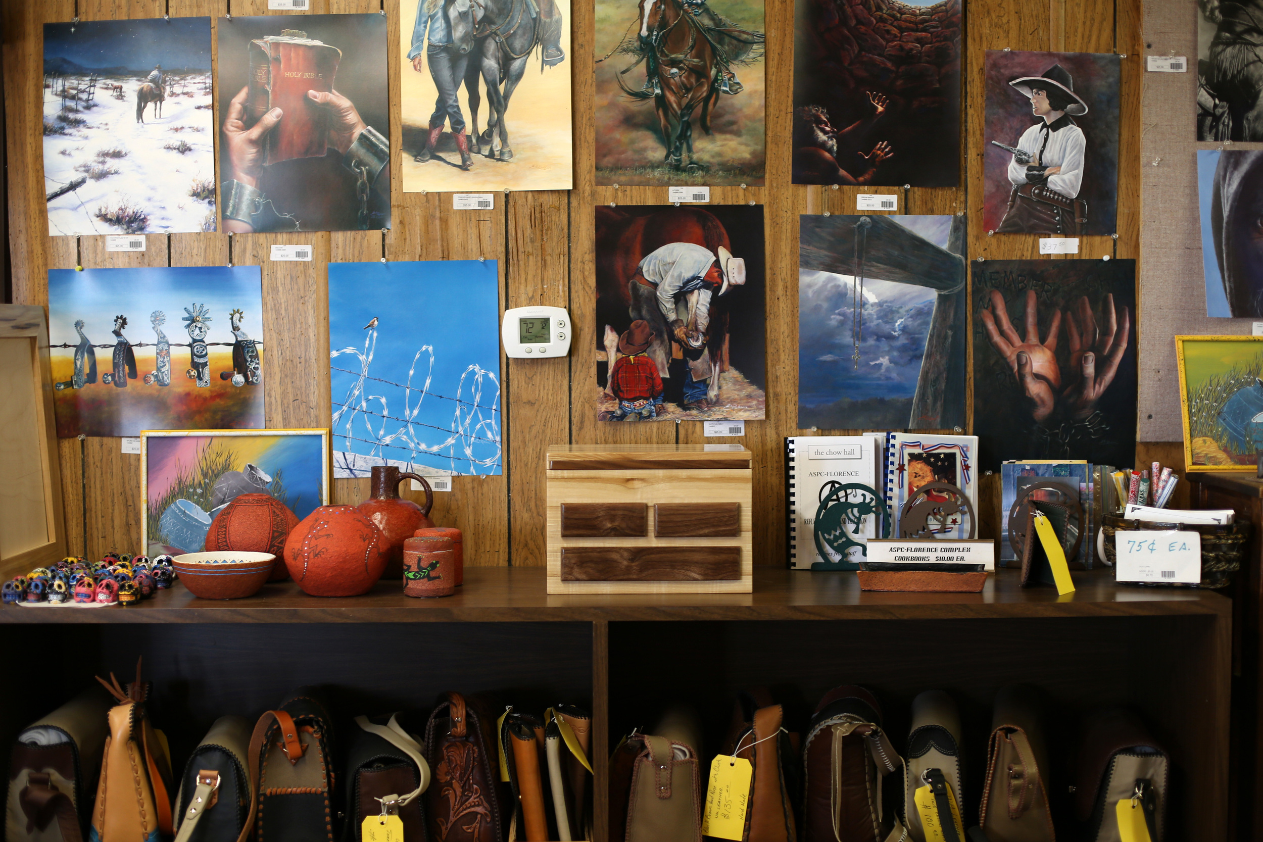 Paintings, leather goods, pottery, and woodwork at the Prison Outlet in Florence, Arizona, which has been in operation for over 25 years. The shop is filled with items made by inmates who receive 75% of profits on each sale, while the remaining profit goes to Arizona Correctional Industries, a self-funded business under the Department of Corrections.