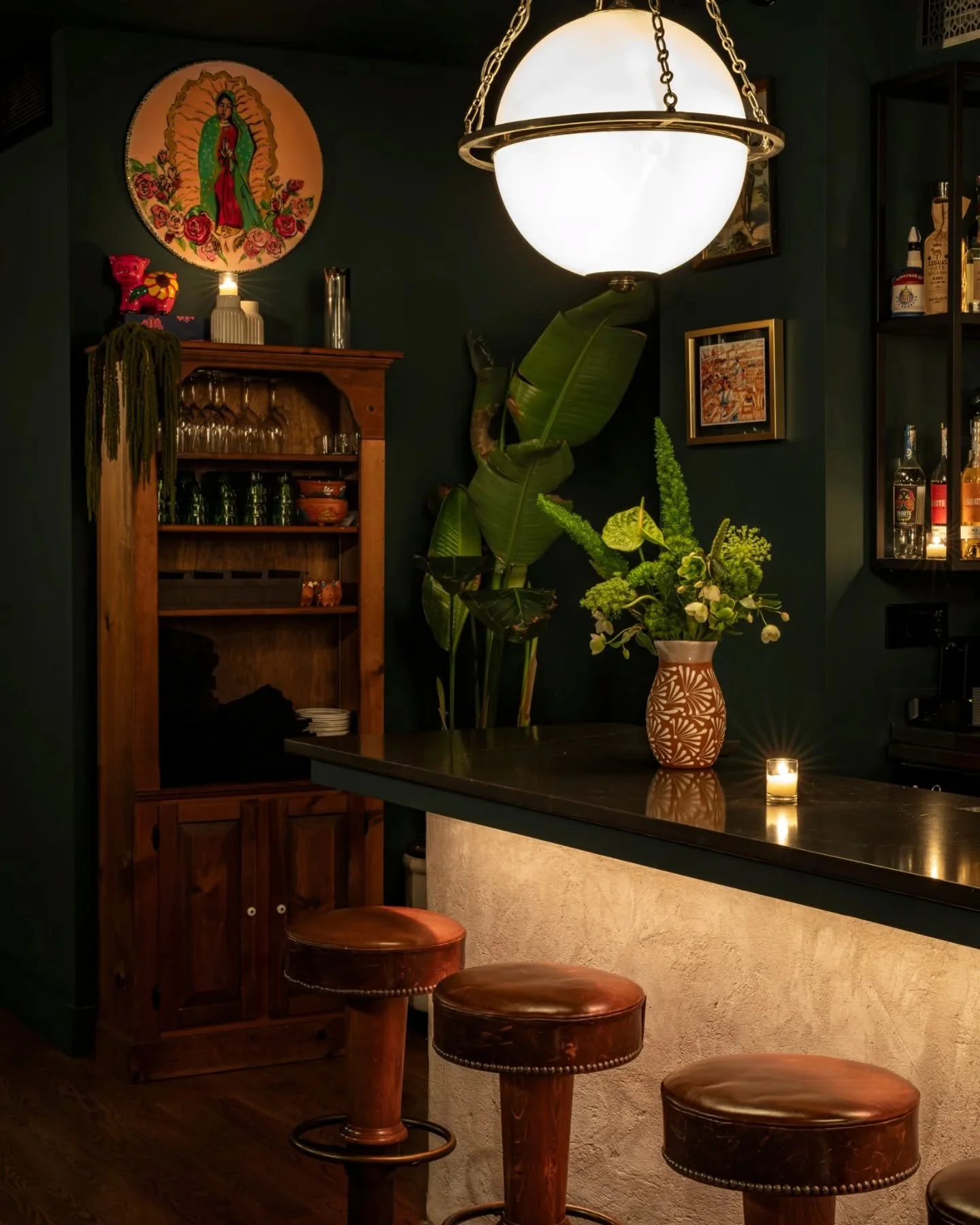 At @cerditomuerto , each detail is designed to spark connection. Family heirlooms tucked between bottles and banquettes connect the bar to its roots. An arched service window keeps the hum of the kitchen front and center, blurring the line between ch
