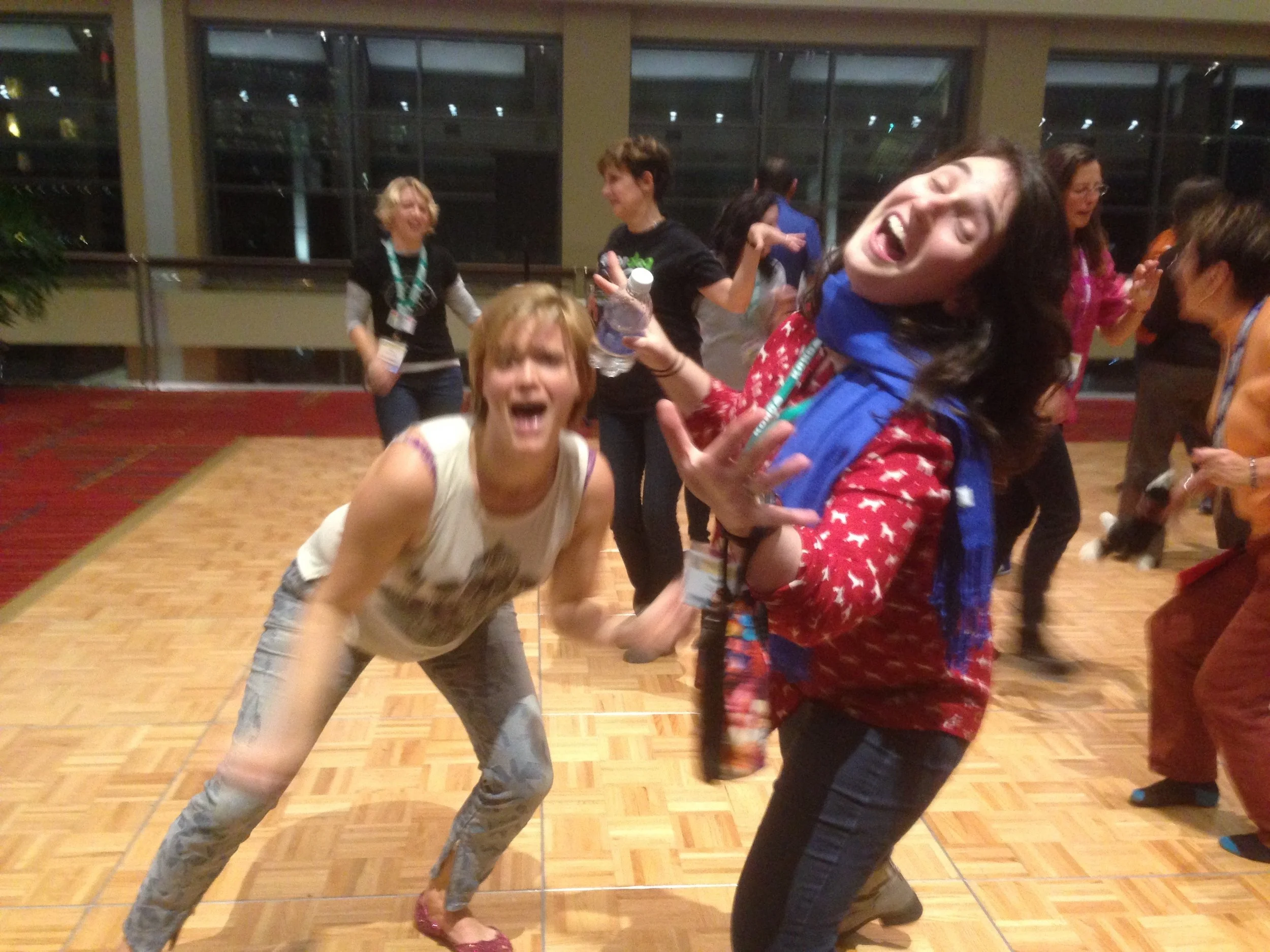 Amanda and Naomi dancing and being silly at a dog training conference in 2015.