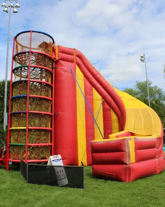 Spider Mountain is the next level of climbing structures for your event! Your guests will find themselves weaving through the interior webbing of this 24' structure! Upon completing this exciting challenge, climbers then have the option of taking a thrilling plummet down our 40' inflatable slide or climbing and squirming back down through the webbing. Climbing through Spider Mountain, comprised of rubber strands enclosed in a soft polyester fabric, is deceivingly challenging and fun for all ages. All exposed hard surfaces are enclosed in four inch padding and the entire attraction is netted. It has been voted "most fun and challenging attraction" on the exhibit floor at many different expositions. You can have up to 25 people inside the 24-foot-tall apparatus at once. There is no harnessing and therefore can maintain a very high throughput! People Per Hour: 100+ Power Requirement: (3) 20 AMPS Set-up Time: 2 Hours