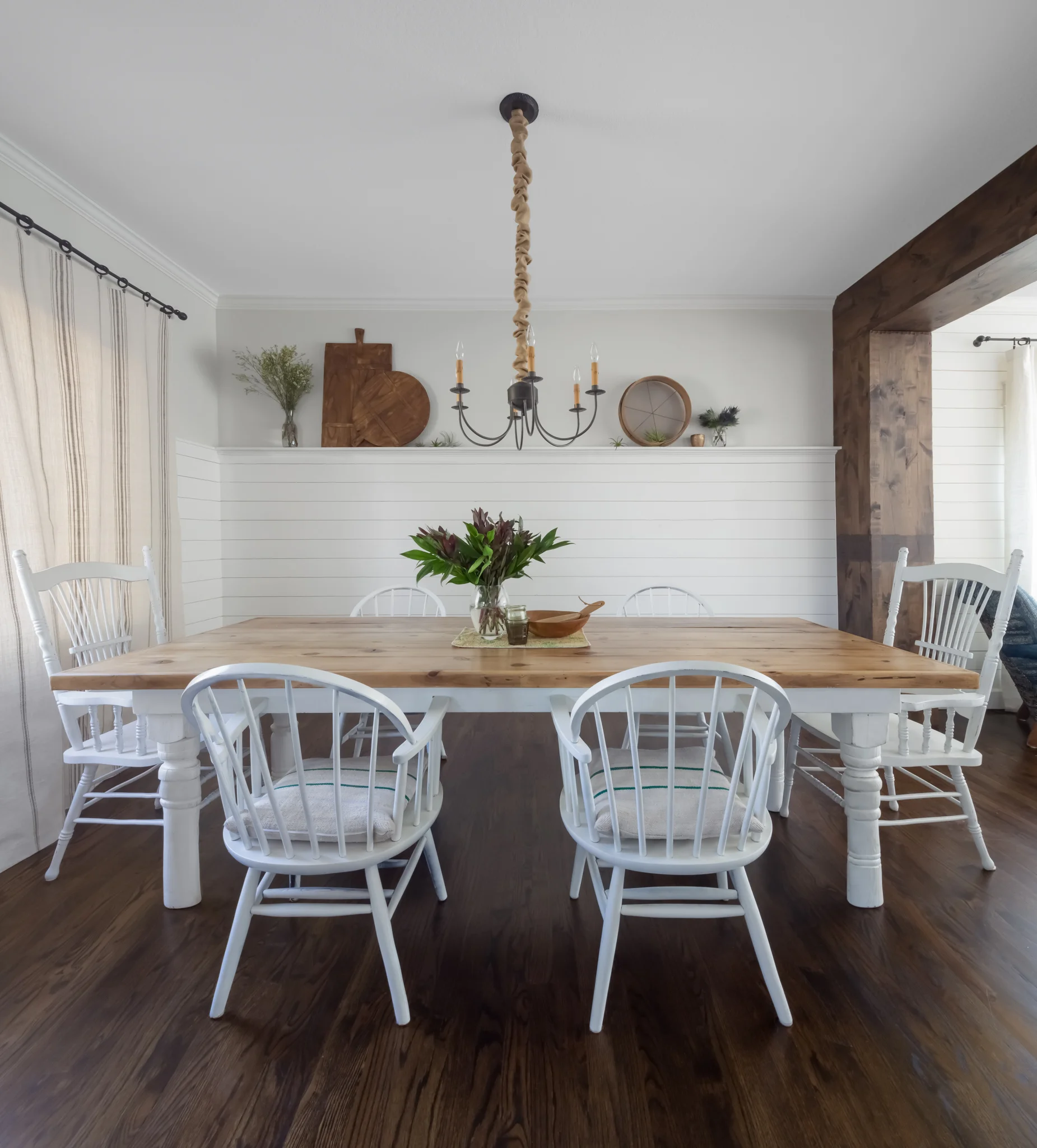 In the dining room, we replaced a generic drywall arch with a custom post and beam. &nbsp;We added planking to the wall to add some visual interest and to give the client a shelf for flexible display.