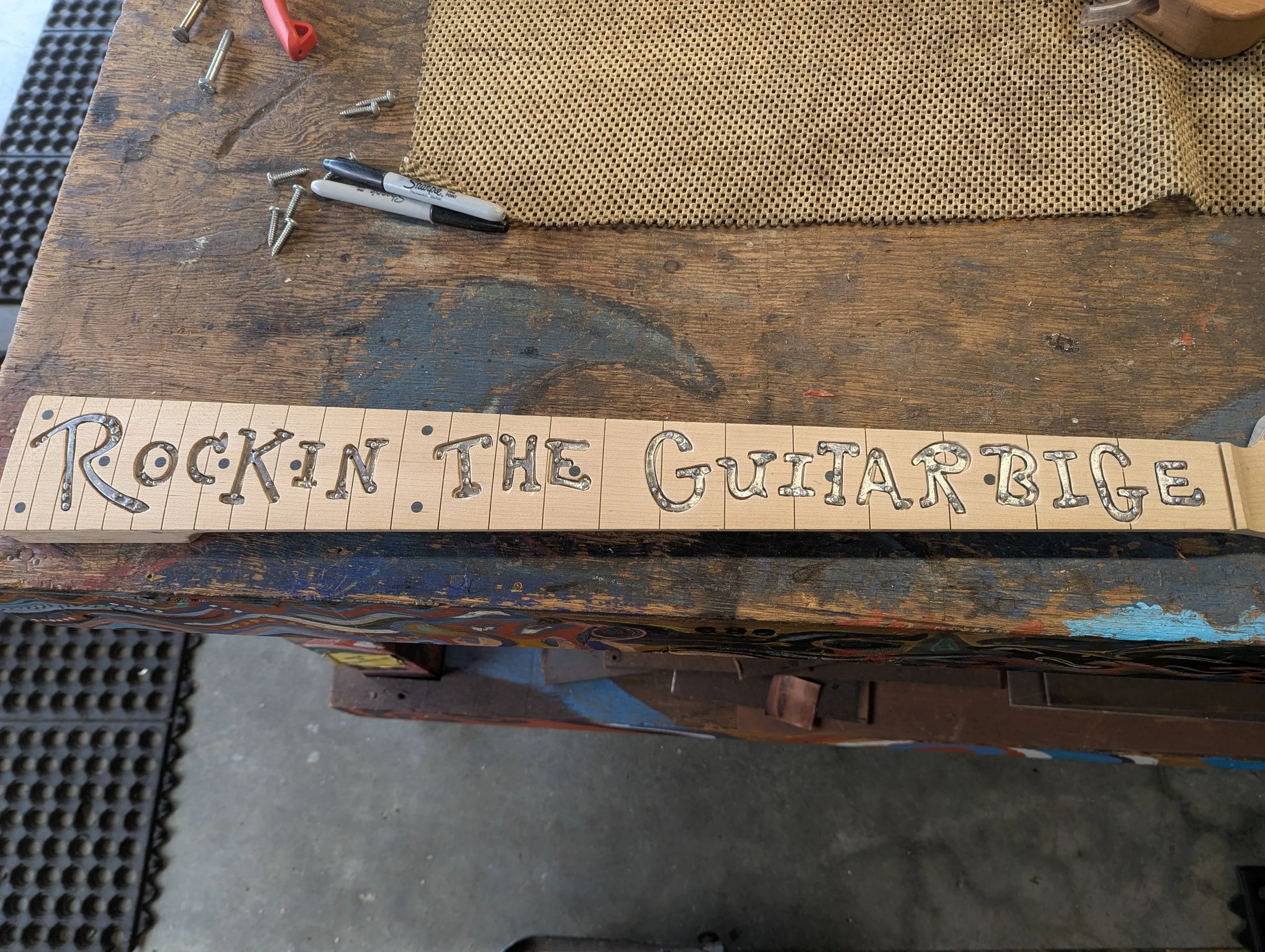 Letters are made of steel and routed in nicely into the geetar neck