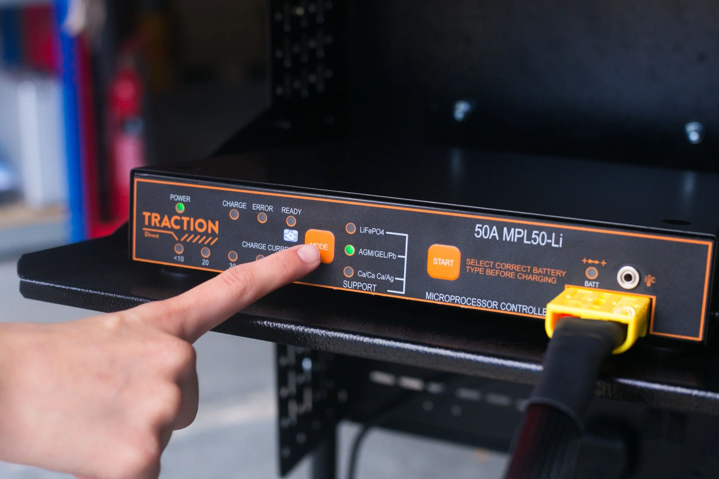 A workshop technician selecting the battery technology on a MPL50 Li Battery Charger