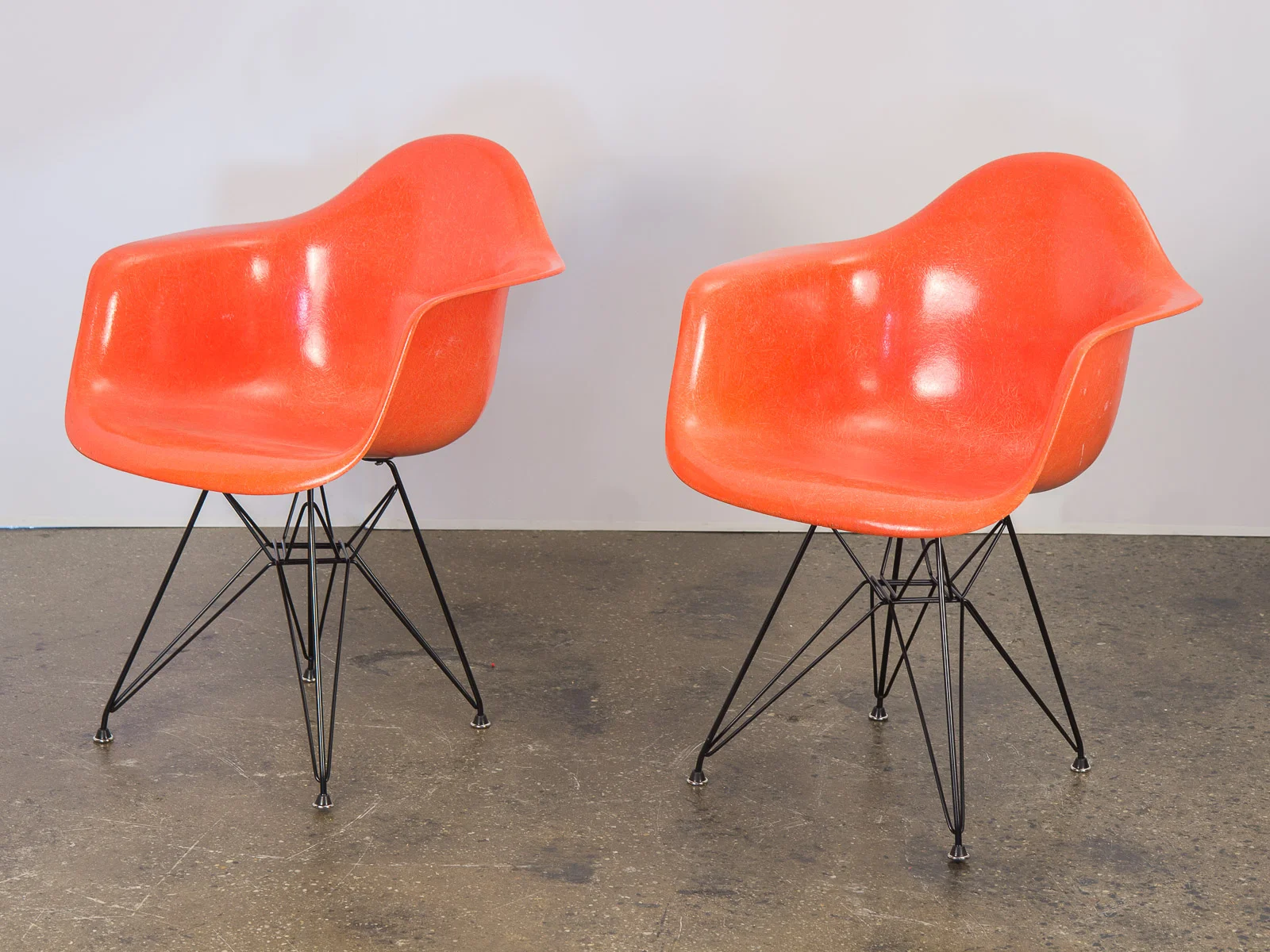 open_air_modern_pair_of_orange_eames_fiberglass_armchairs_for_herman_miller_on_black_eiffel_base-2.jpg