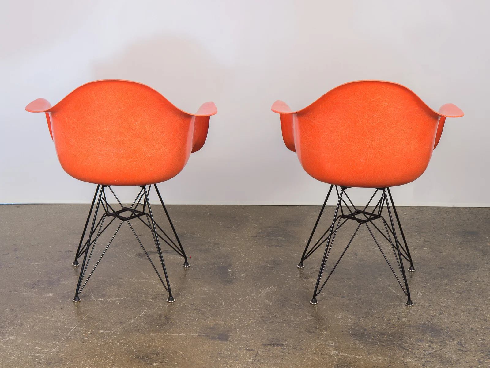 open_air_modern_pair_of_orange_eames_fiberglass_armchairs_for_herman_miller_on_black_eiffel_base-5.jpg