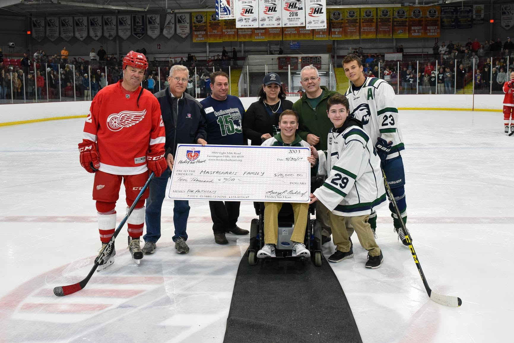 Hockey has Heart supporters presenting a check to a hockey family on the ice