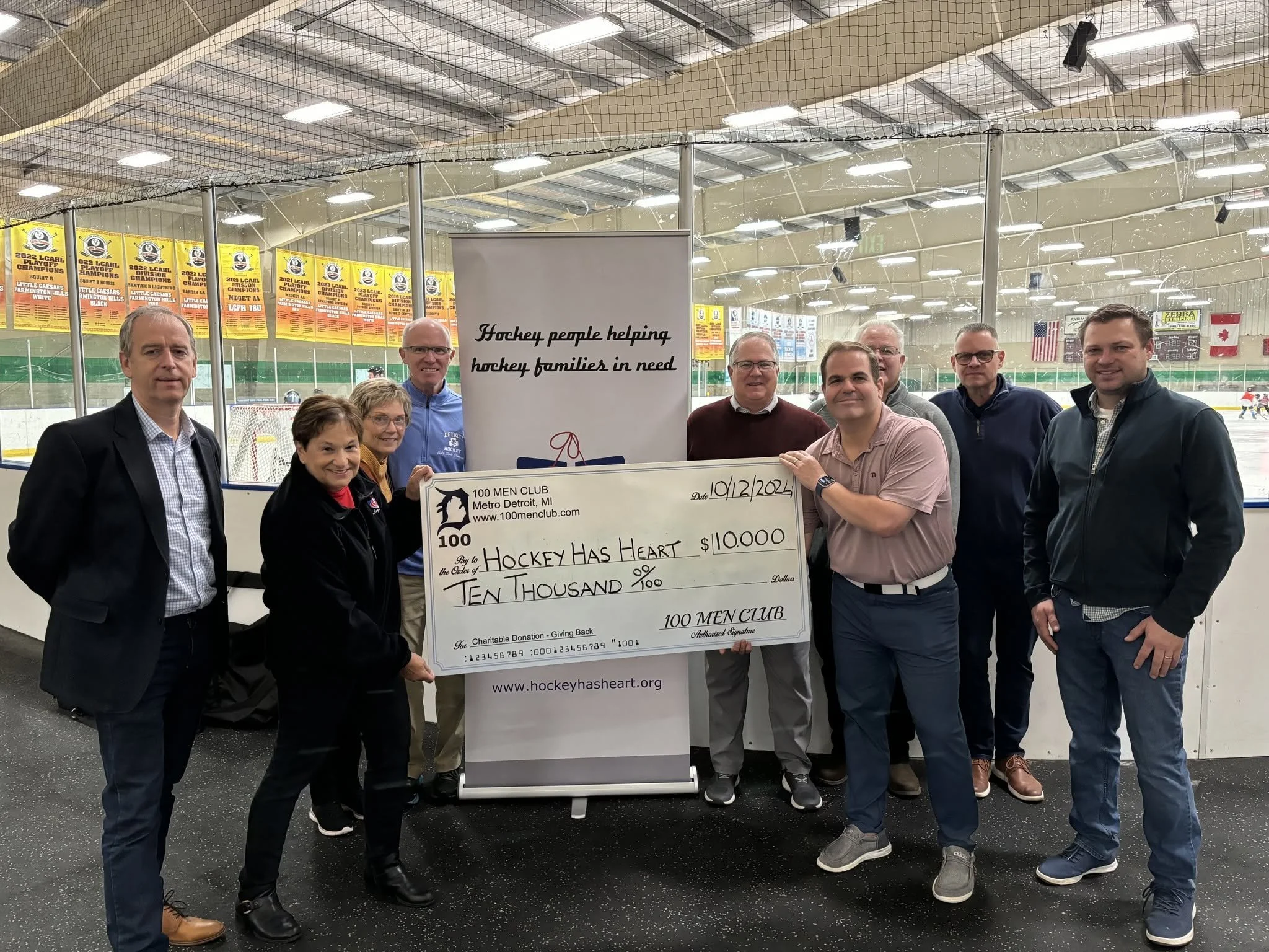 100 Men Club presenting a $10,000 check to Hockey has Heart at the rink