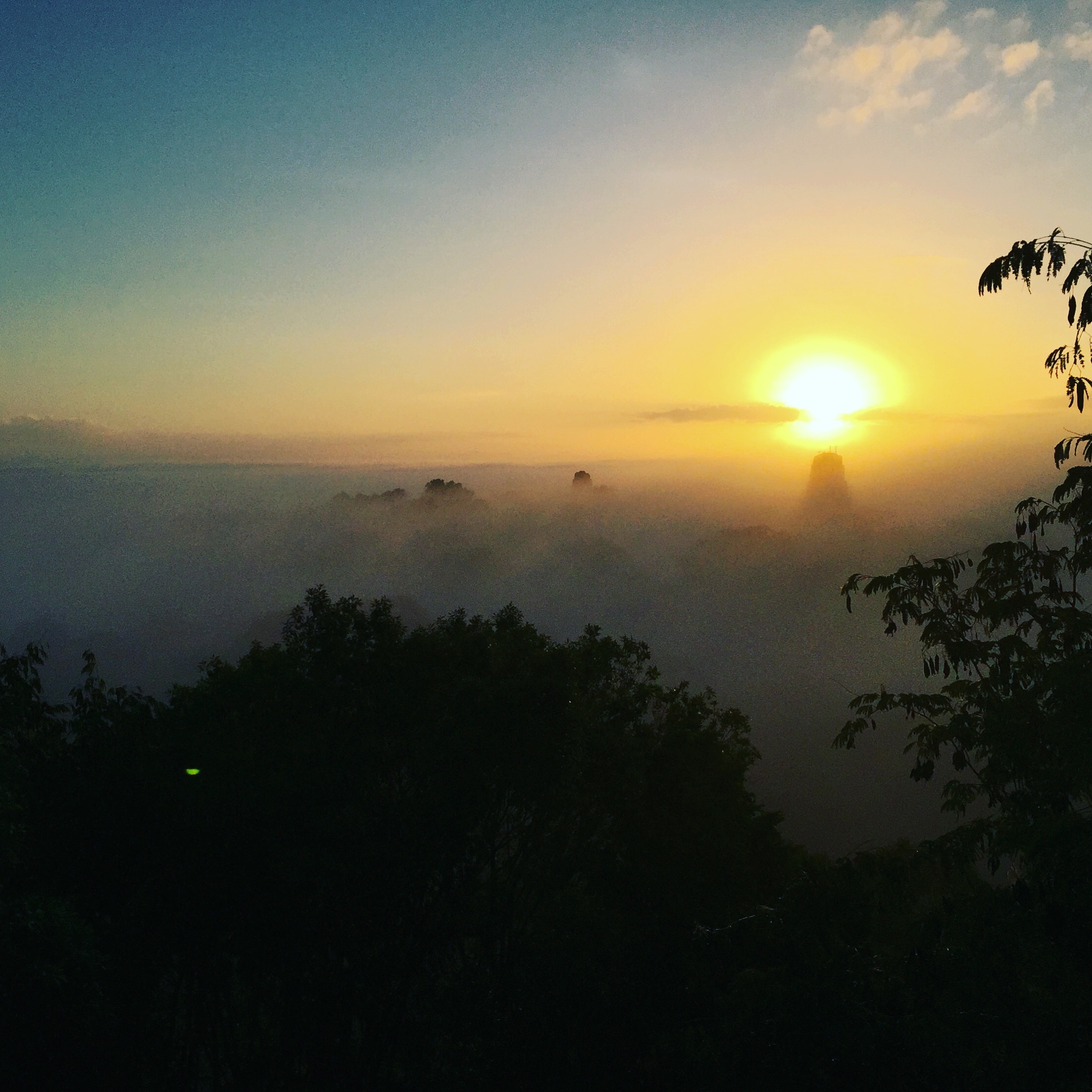 Sunrise from on top of a temple ruin. In the distance you can see a few of the other temples begin to take shape above the cloud line. The sound of the waking howler monkeys made us feel as if we were in Jurassic Park.