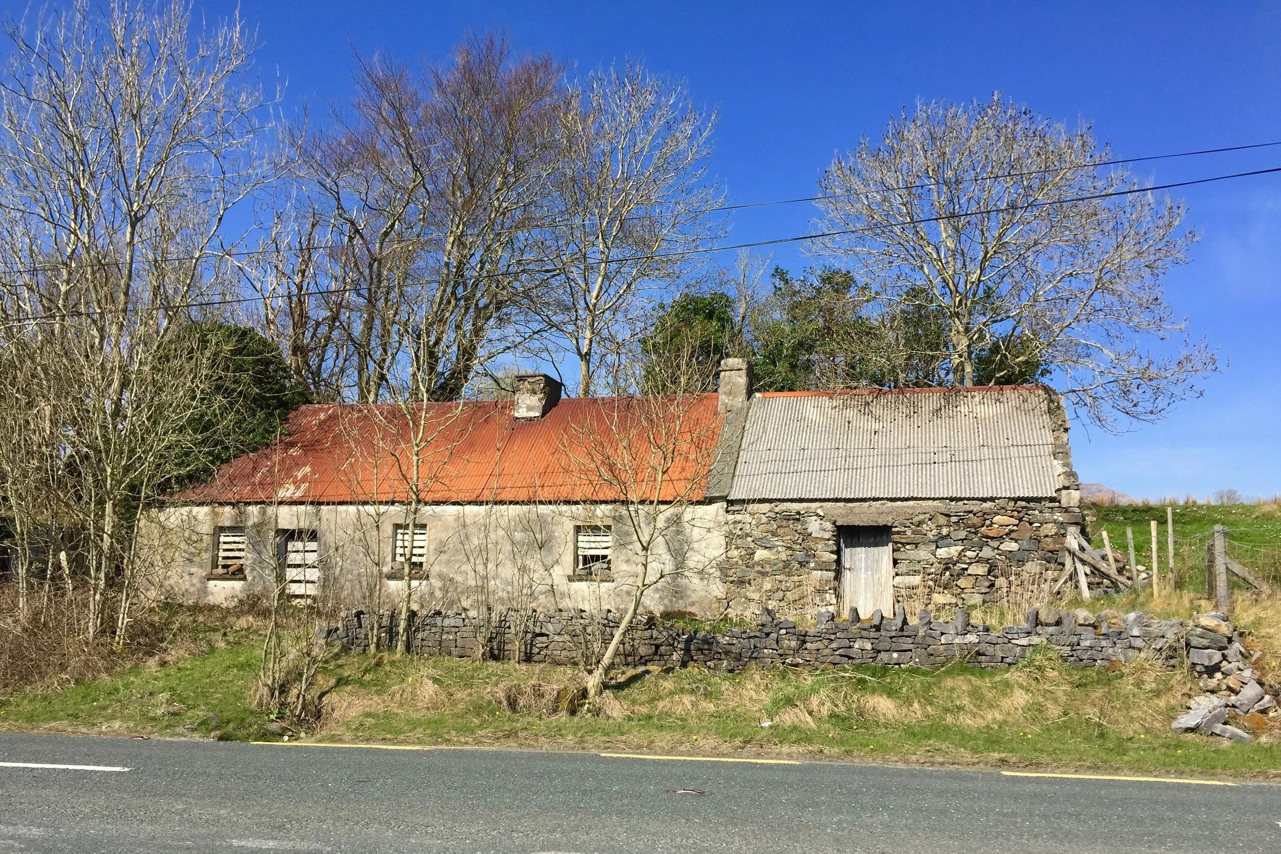 The road to Clifden is covered with rolling farmland and quaint stone cottages like this one.