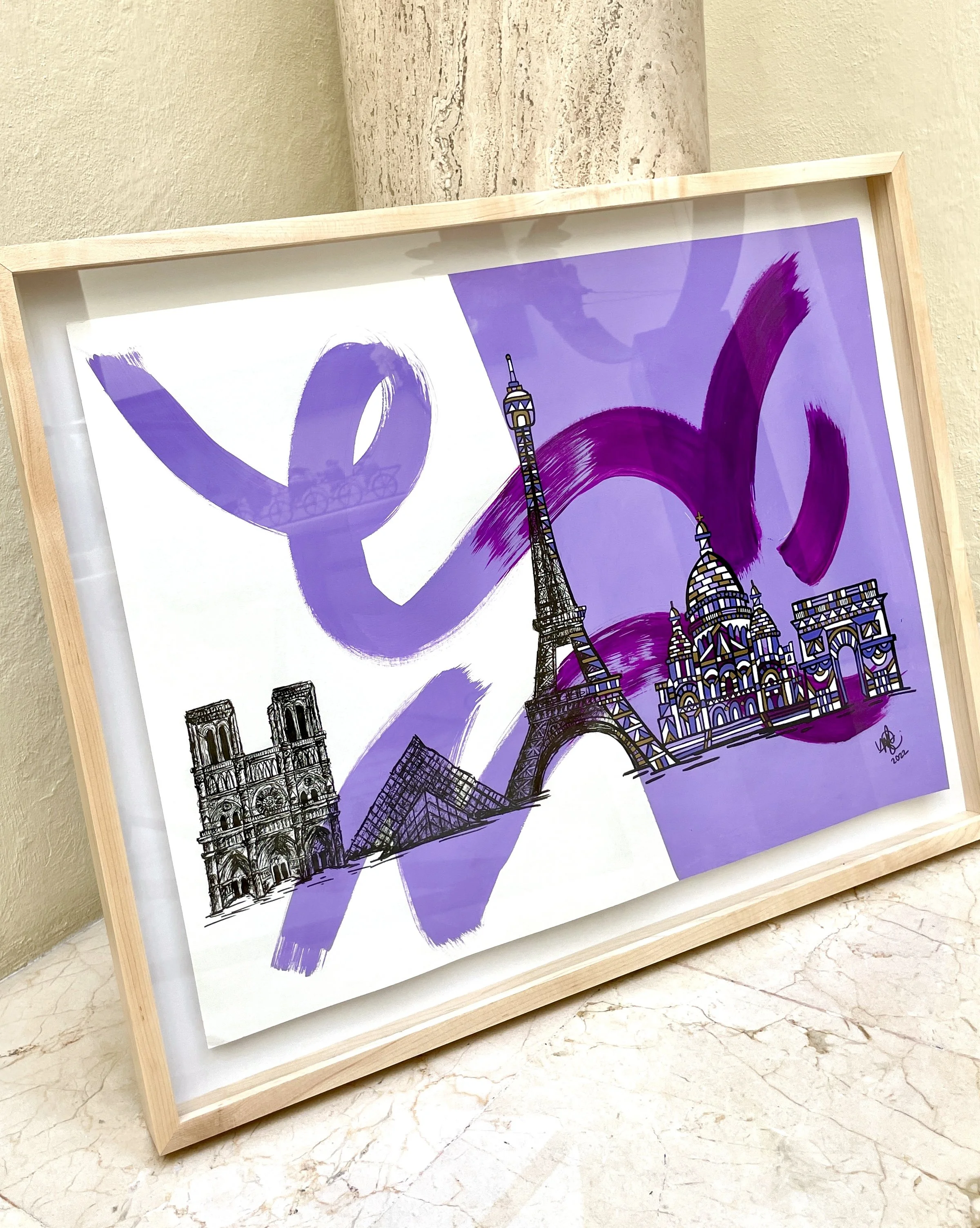 Framed artwork featuring sketches of Paris landmarks including the Eiffel Tower, Notre Dame Cathedral, the Louvre Pyramid, and Saint Basil's Cathedral, with purple brushstroke accents.
