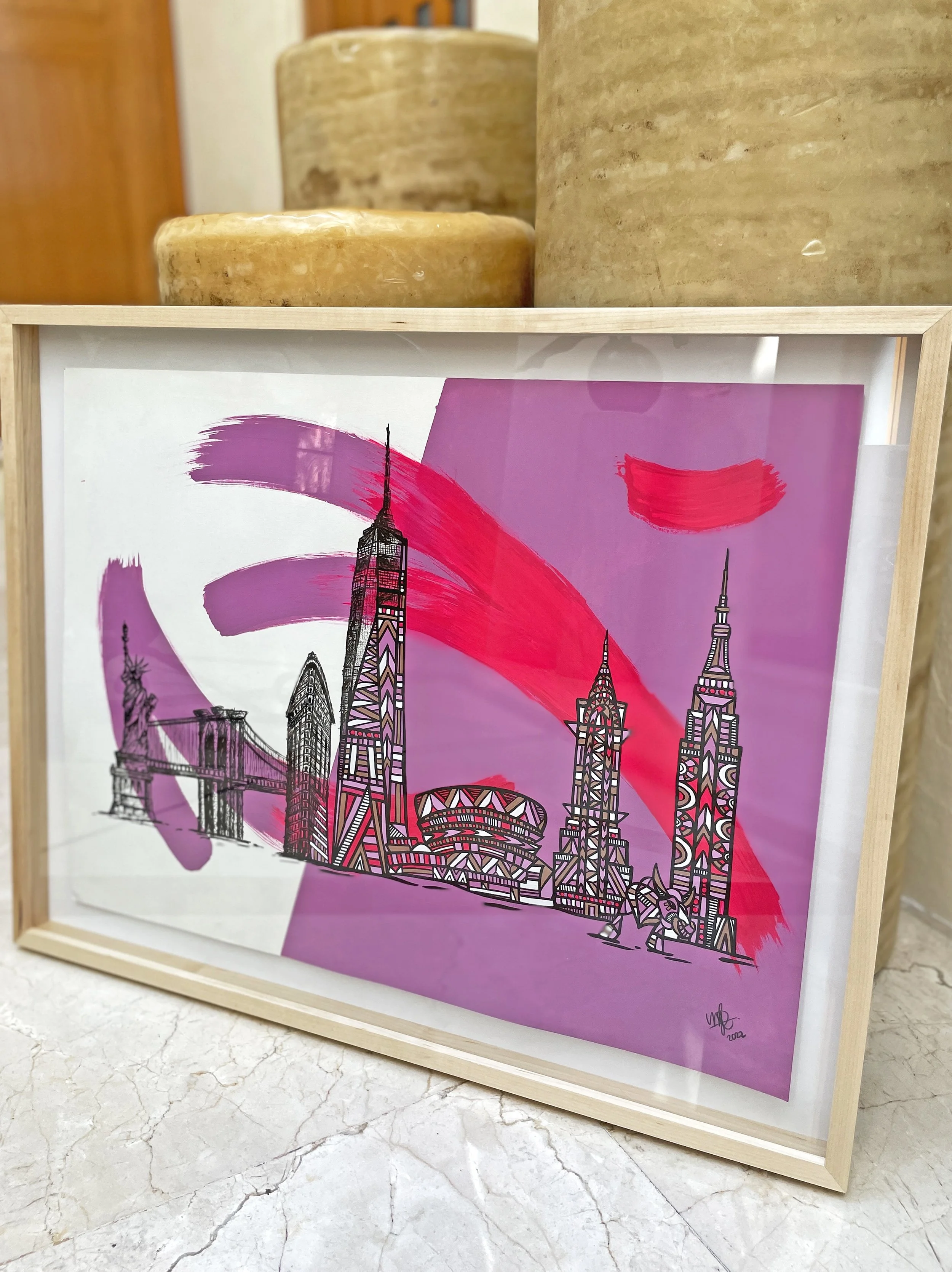 Framed artwork of New York City skyline with stylized purple and pink brushstrokes, including the Empire State Building, One World Trade Center, and Brooklyn Bridge, on a purple background.