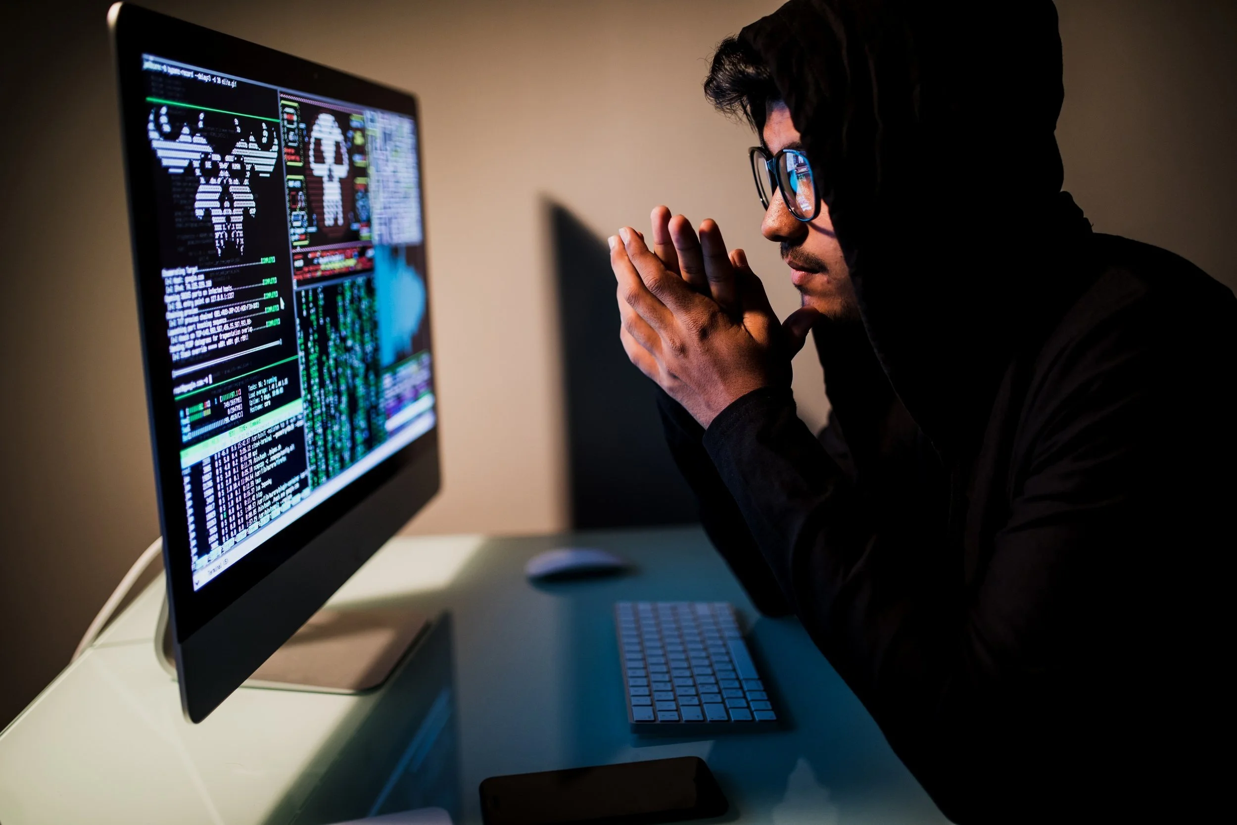 indianmale-hacker-with-smartphone-coding-computers-screen-dark-room.jpg