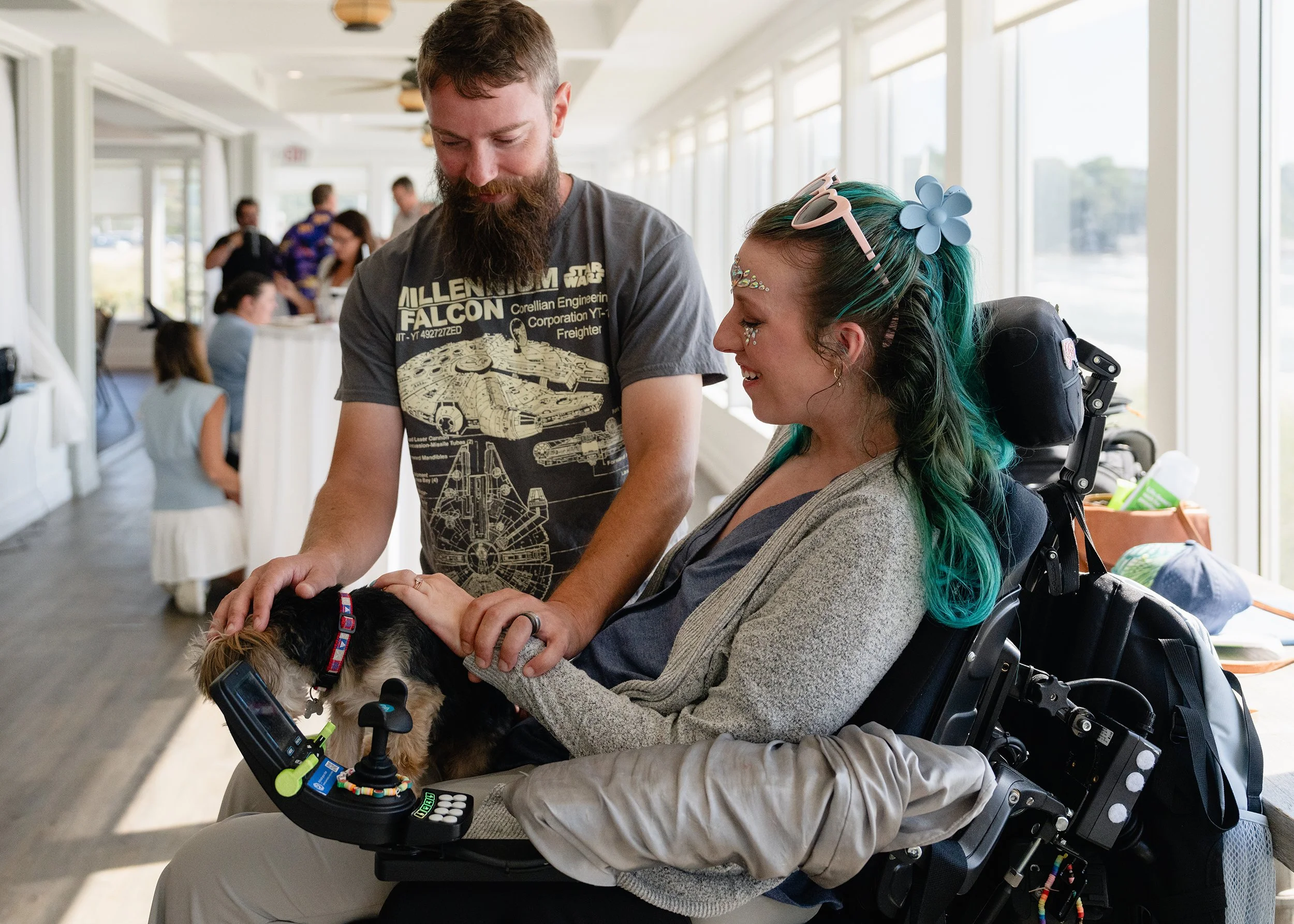 Josh Isaacs helps his wife Laura McNew-Isaacs pet a dog by guiding her hand.