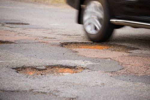 Cracked wheel after pothole impact on Nassau County road