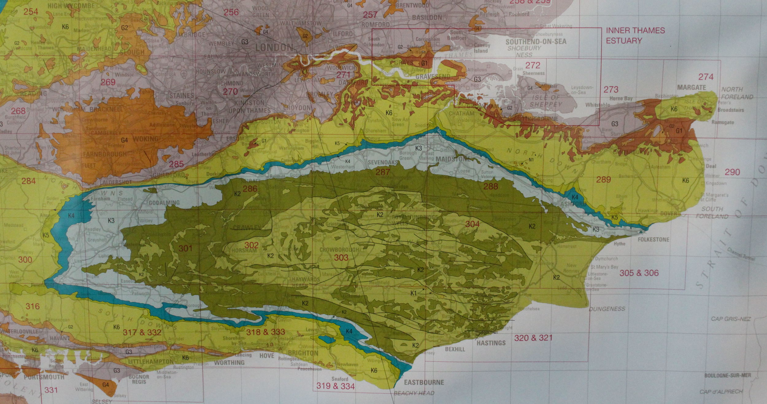 The Greensand Ridge, encircling the Weald of Kent and Sussex, shown in light blue in this terrible photo of a geological map. It's the remainder of a layer of greensand deposit which has been eroded away until just the edges remain; the north and south downs (mustardy-green) are a similar remainder, but of the layer of chalk that was laid above the greensand in the Cretaceous period.