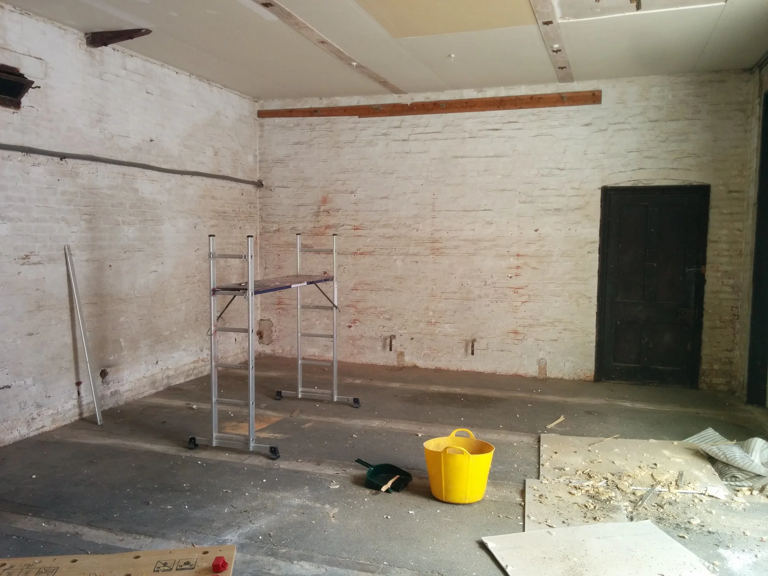 This is the Warehouse area before work started. Well, i'd done some exploratory work with a sledgehammer. You can see the stone runners of the Coach House floor where the cart wheels would have run, off the earth floor.