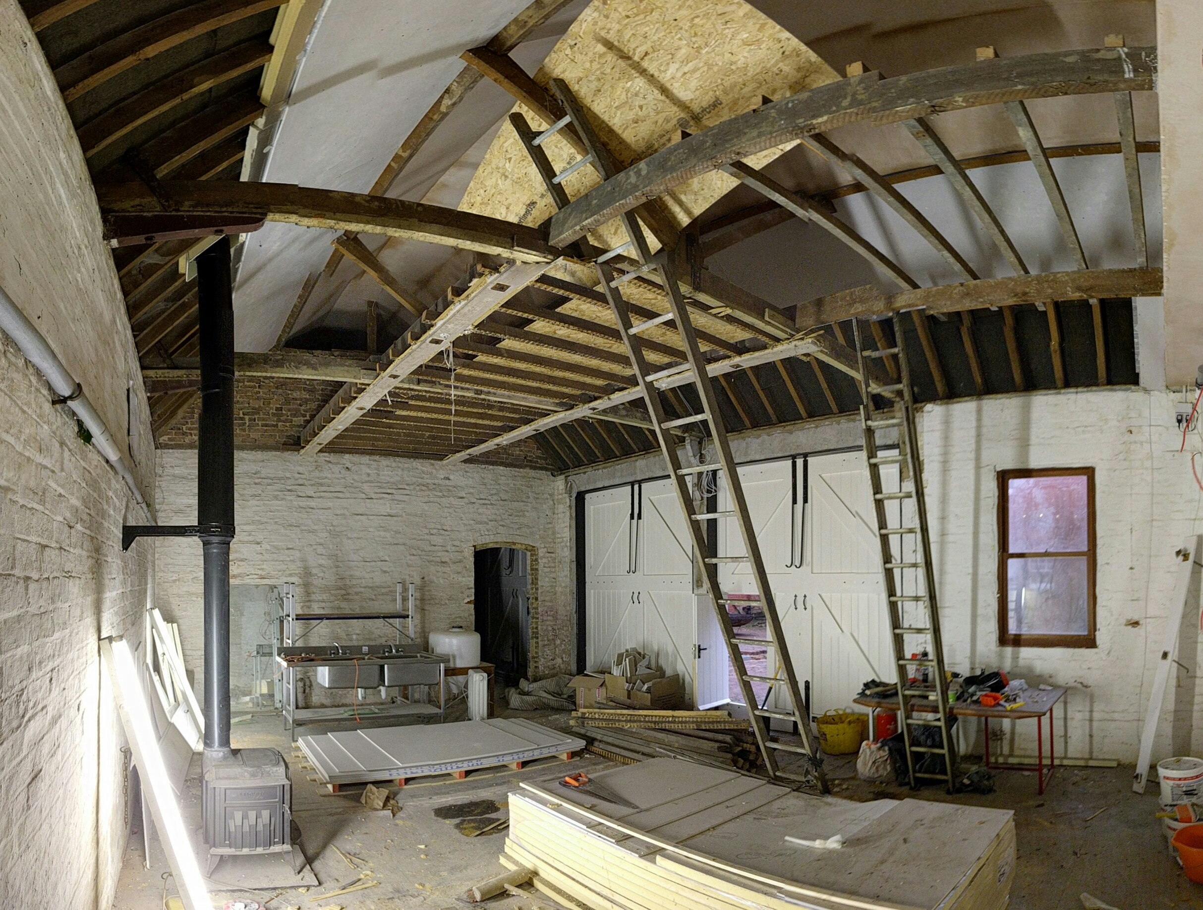 Here is the Warehouse building with much of the ceiling insulation & board in and most of the ceiling boards out. The stove has also gone in and all those beams will keep us warm for at least two years!