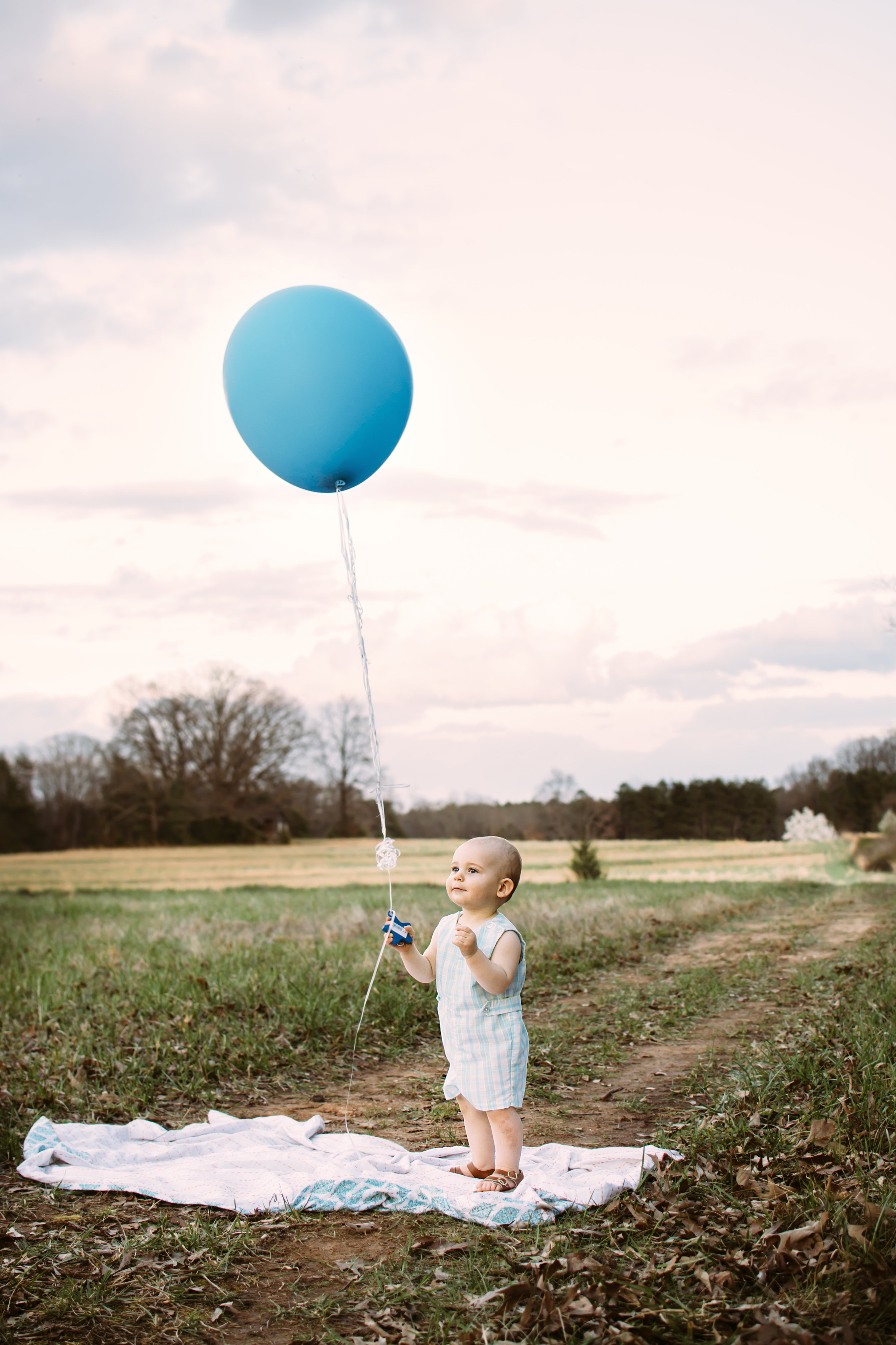 Baby holding large balloon