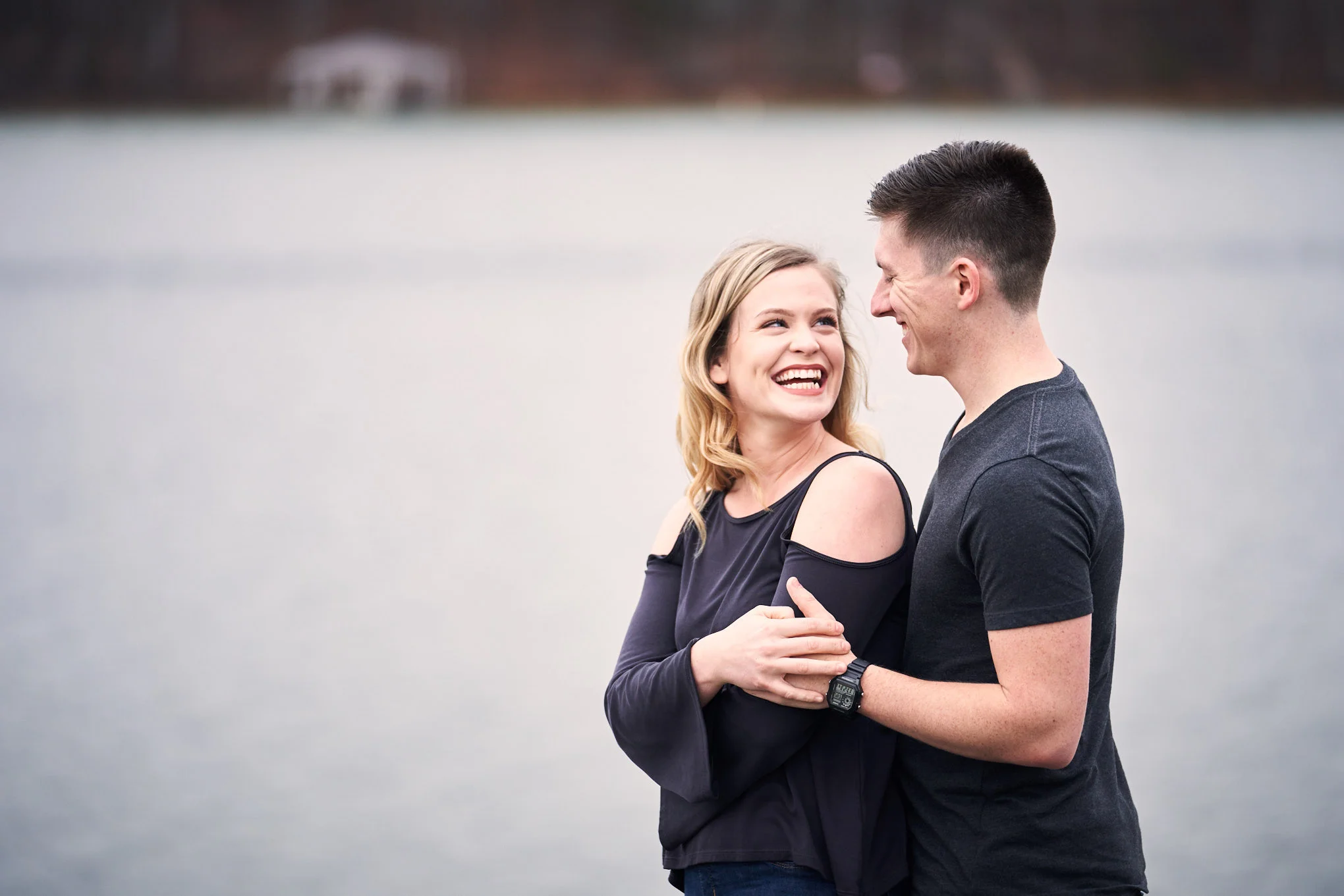 Couple looking at each other next to lake | Engagement Session in Clemson, SC