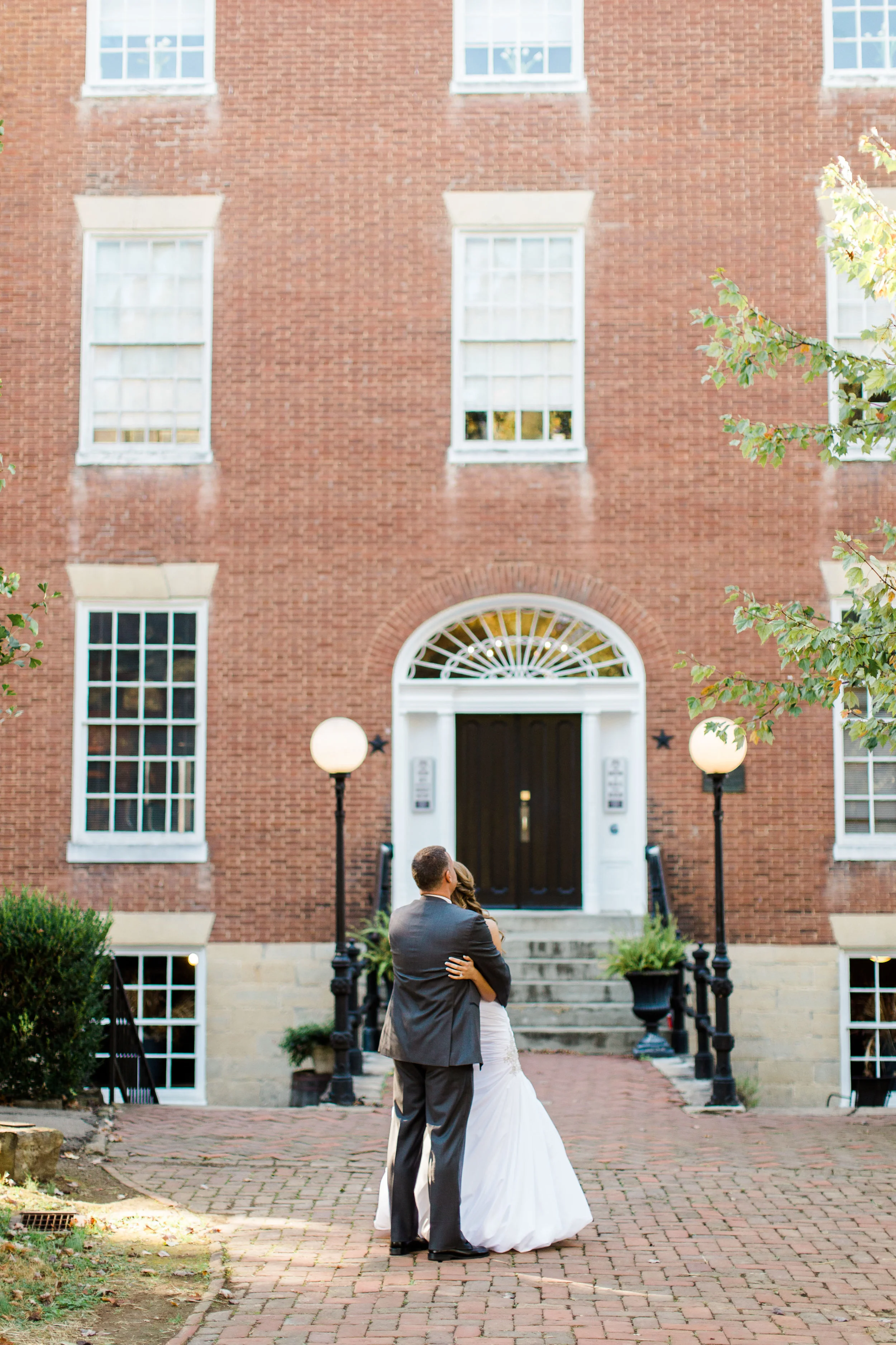 Bride and groom embrace during their first look outside Oscar-Getz