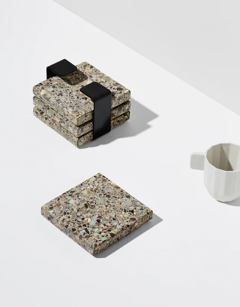 Habitat Set - Habitat is a 4-piece trivet set, made from natural, earthy Terrazzo stone. Finished with a steel band to house them when not in use. They make a textural addition to any tabletop. Use them as individual coasters or piece together for a…