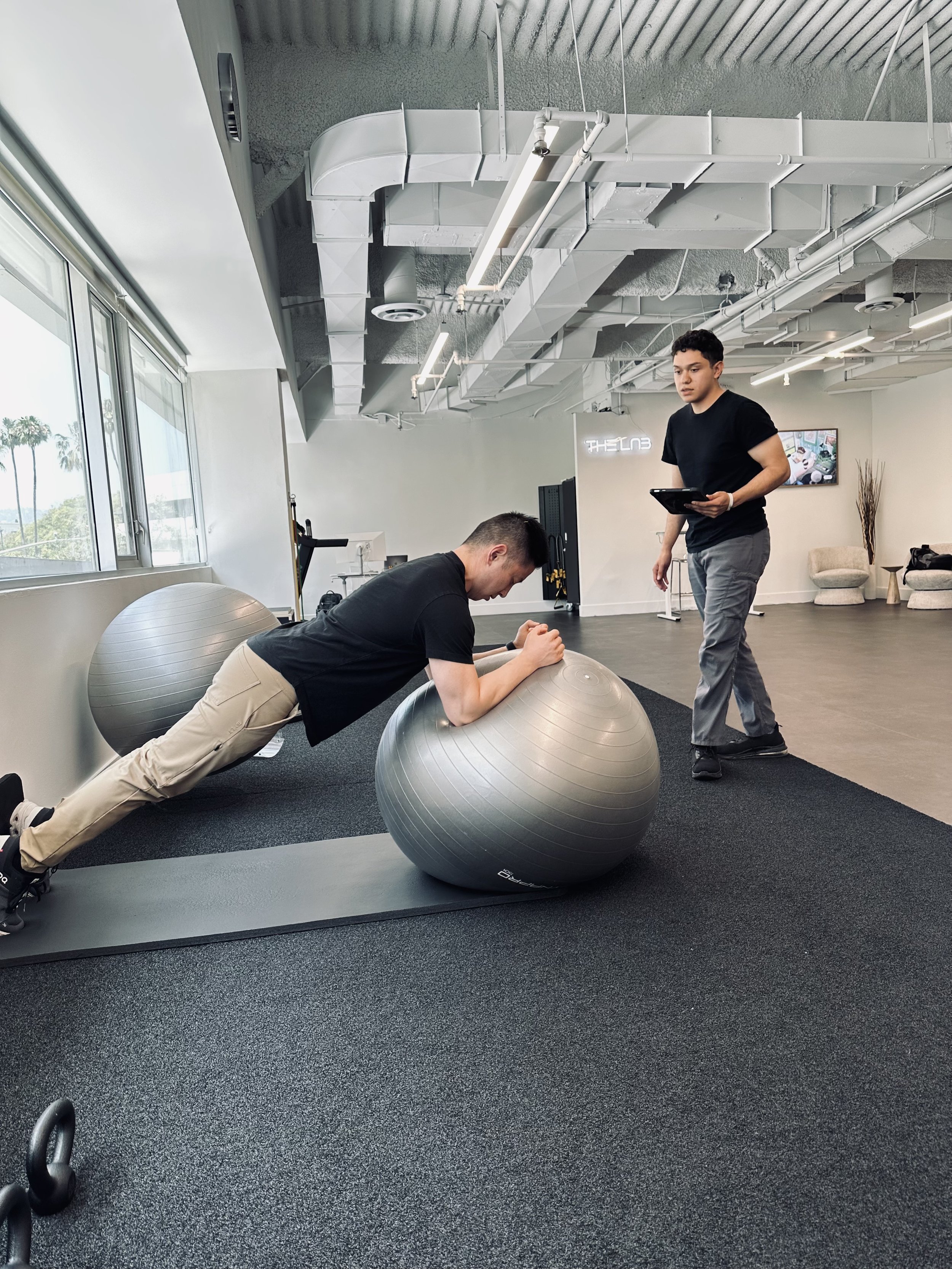 physical therapist teaching patient how to perform core strengthening exercise