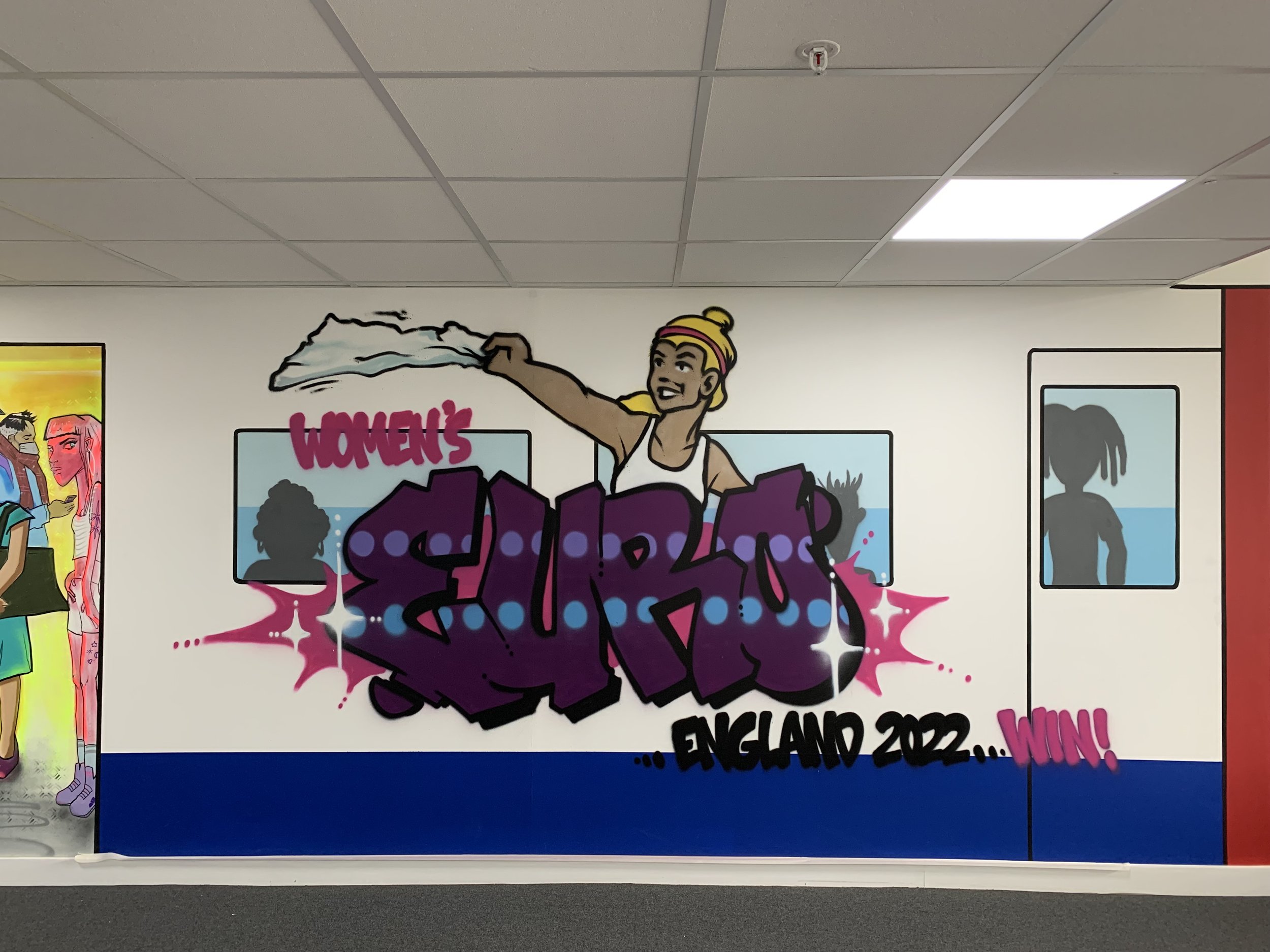 "Wembley Way" Tube station and ball sport themed mural along both sides of a huge corridor in the Bedford Heights commercial development for Verve Properties.  Bedord, August 2022. 