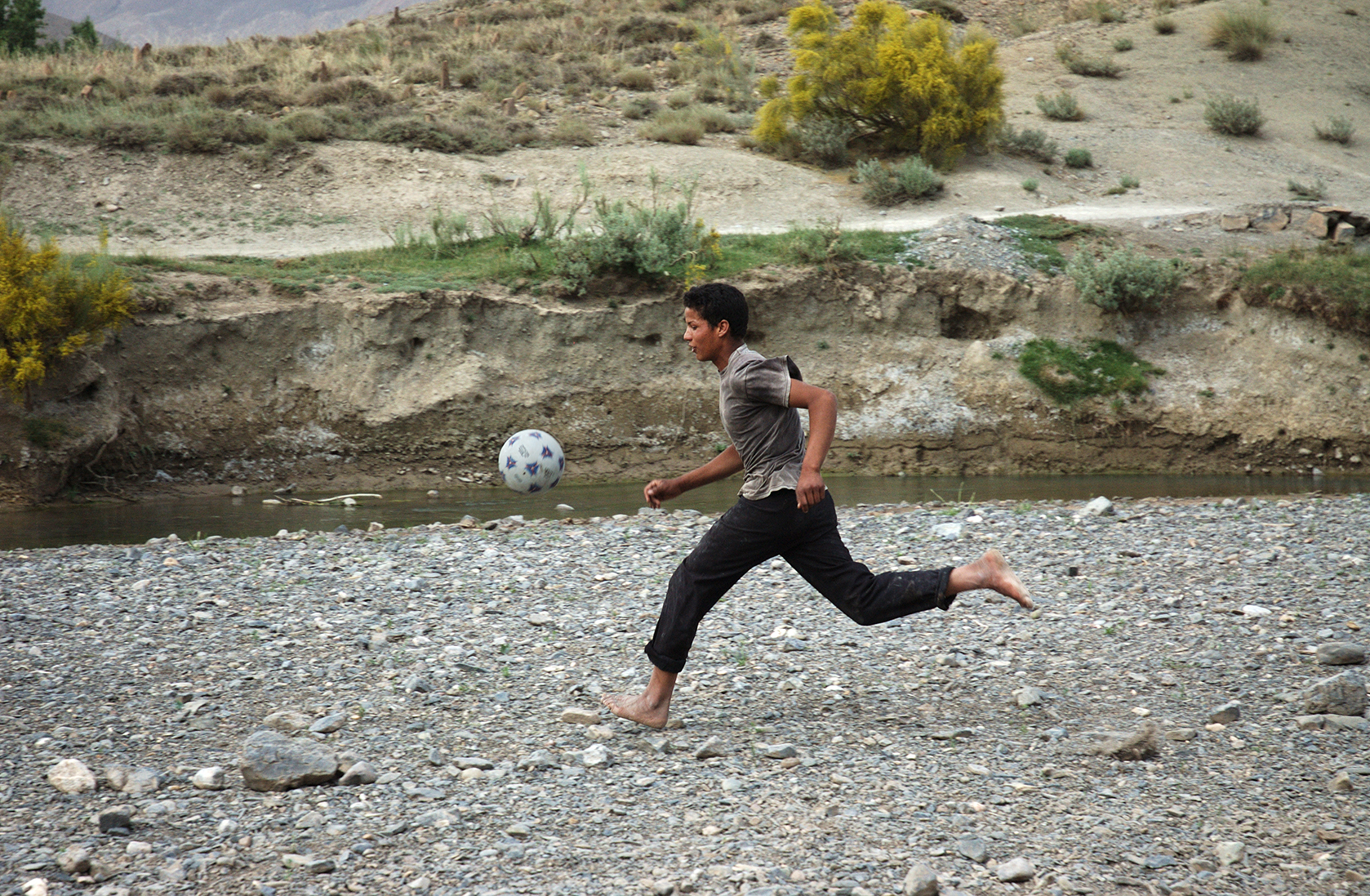 Playing soccer on the dry river bed.