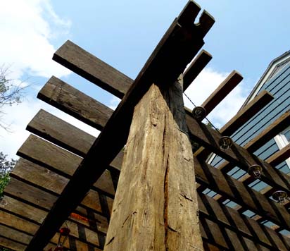A pergola of reclaimed rafters and beams adds personality to your backyard.