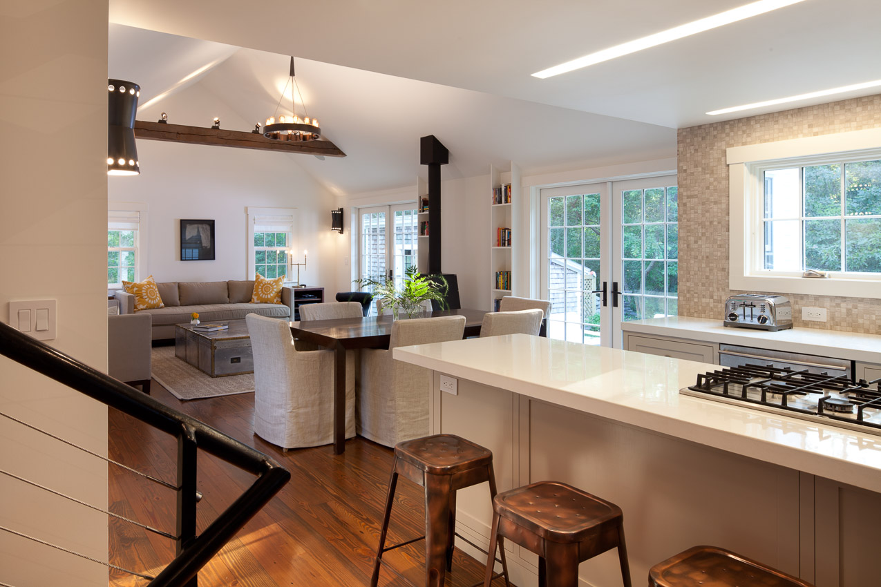 View of kitchen, dining and living room in parsonage, including concrete kitchen countertop.
