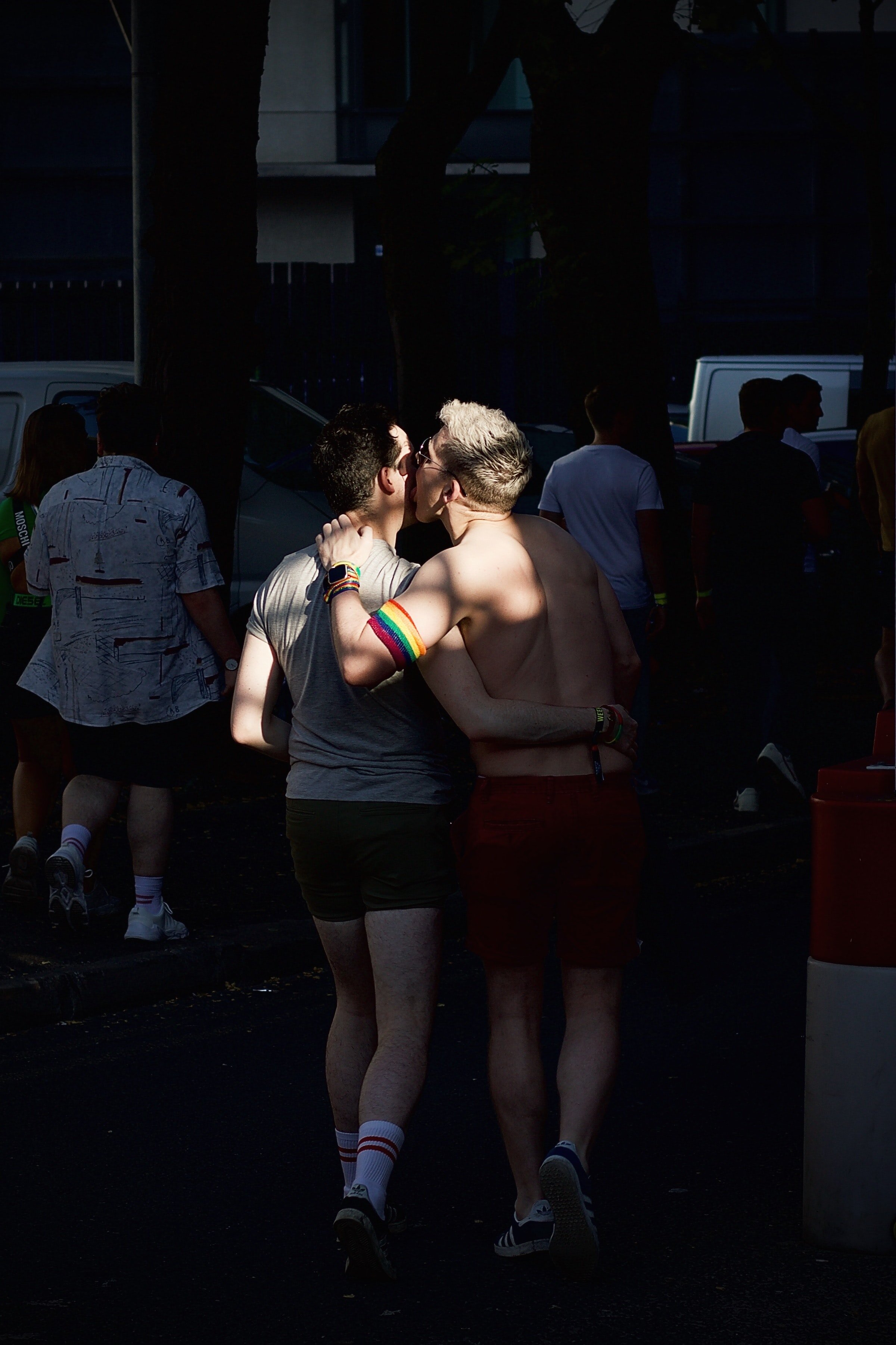 image of a couple from behind and one person is kissing the other on the cheek. 