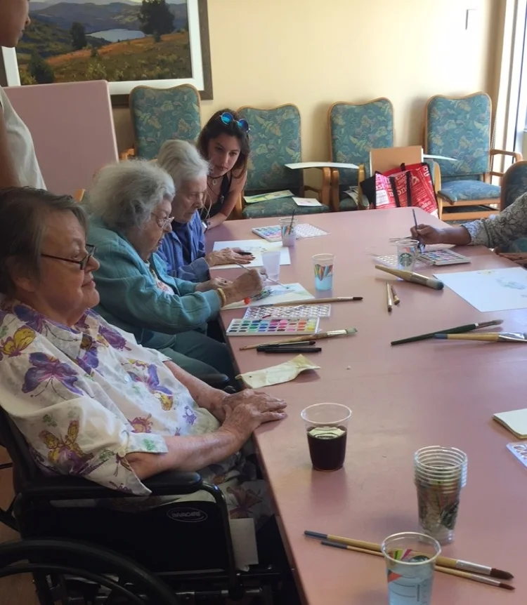  One of our volunteers is sitting with a few of our artists-Muriel, Bette, and Henrietta 