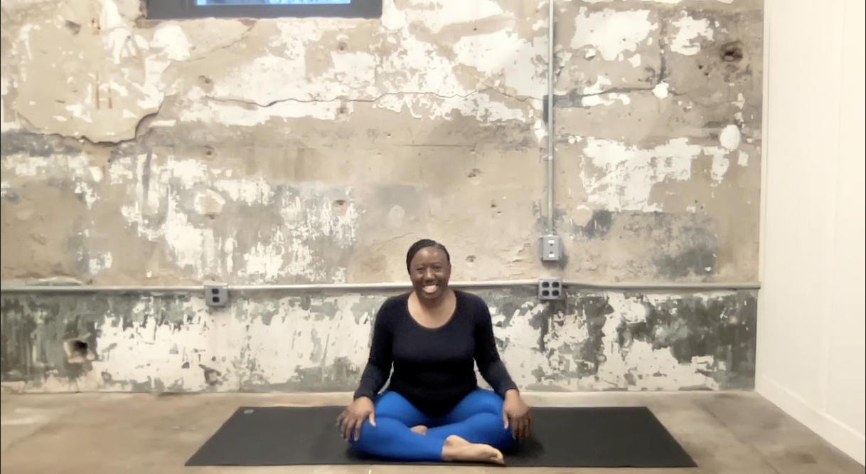 Ivory Howard sits on yoga mat with crossed legs.