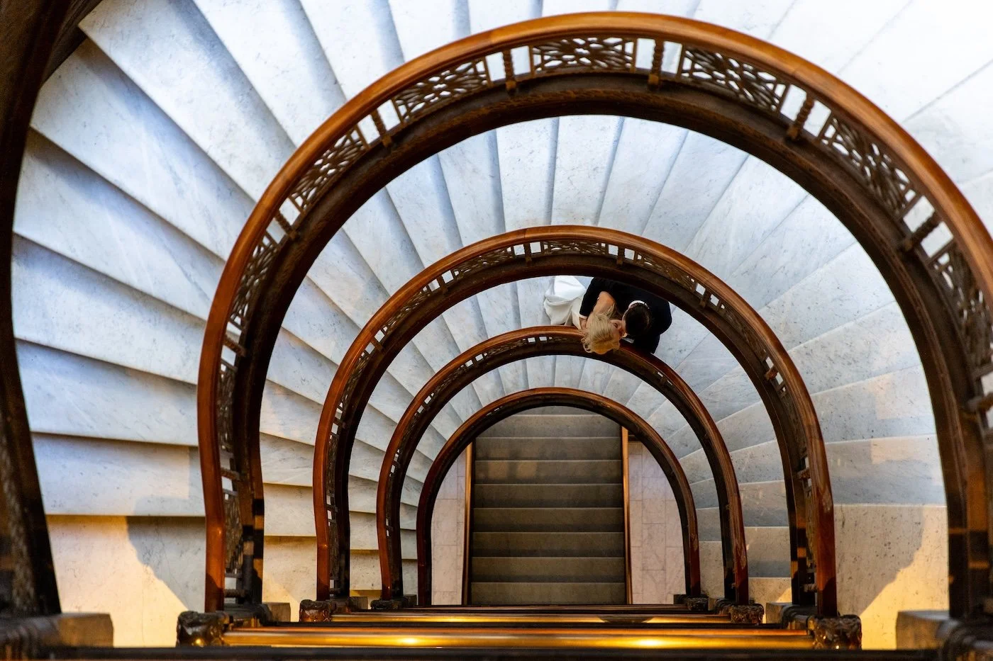 A bride and groom kiss as seen from above in the Rookery Building in Downtown Chicago on the famous staircase