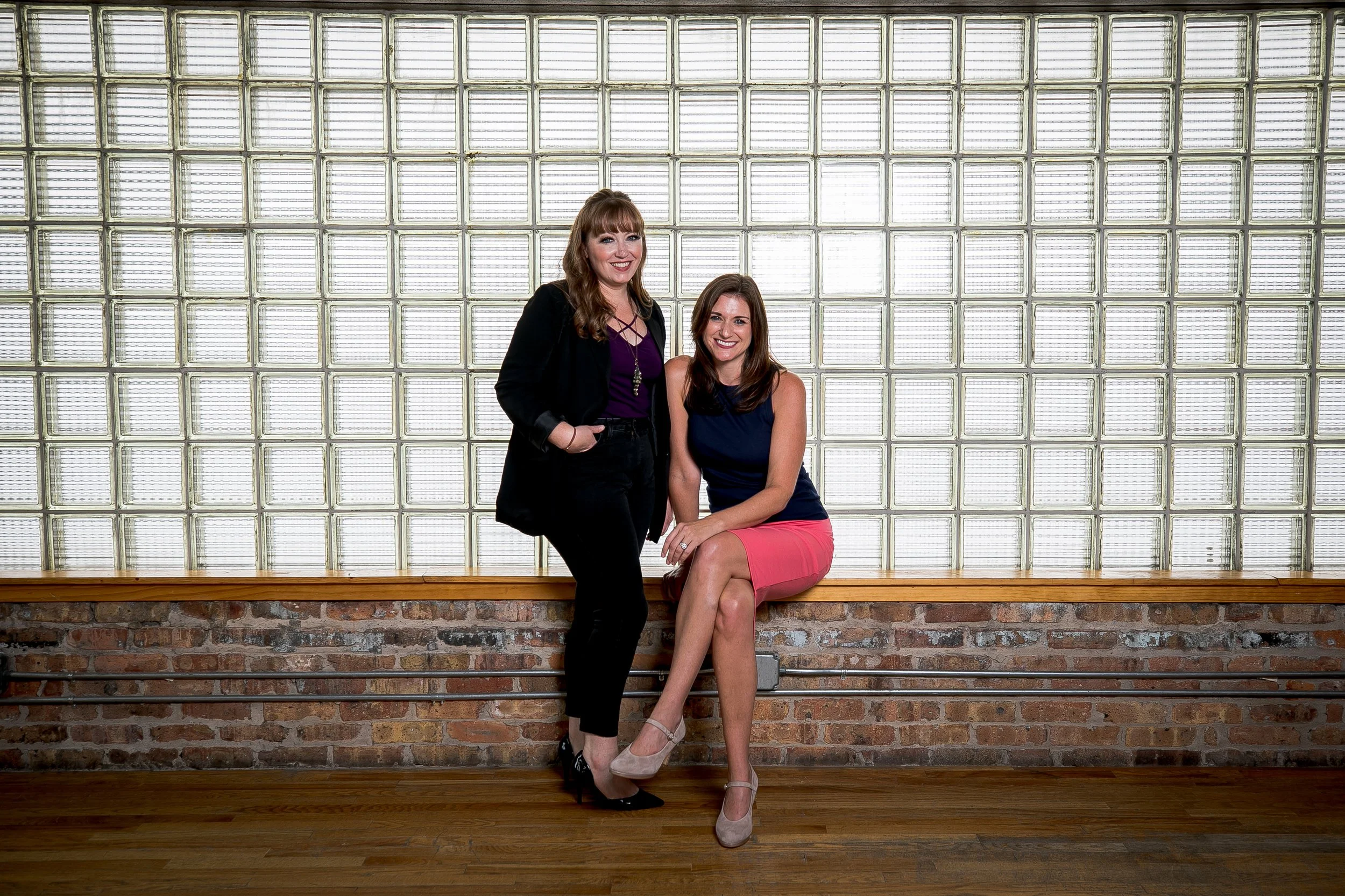 wedding planners business owners together in front of glass block window