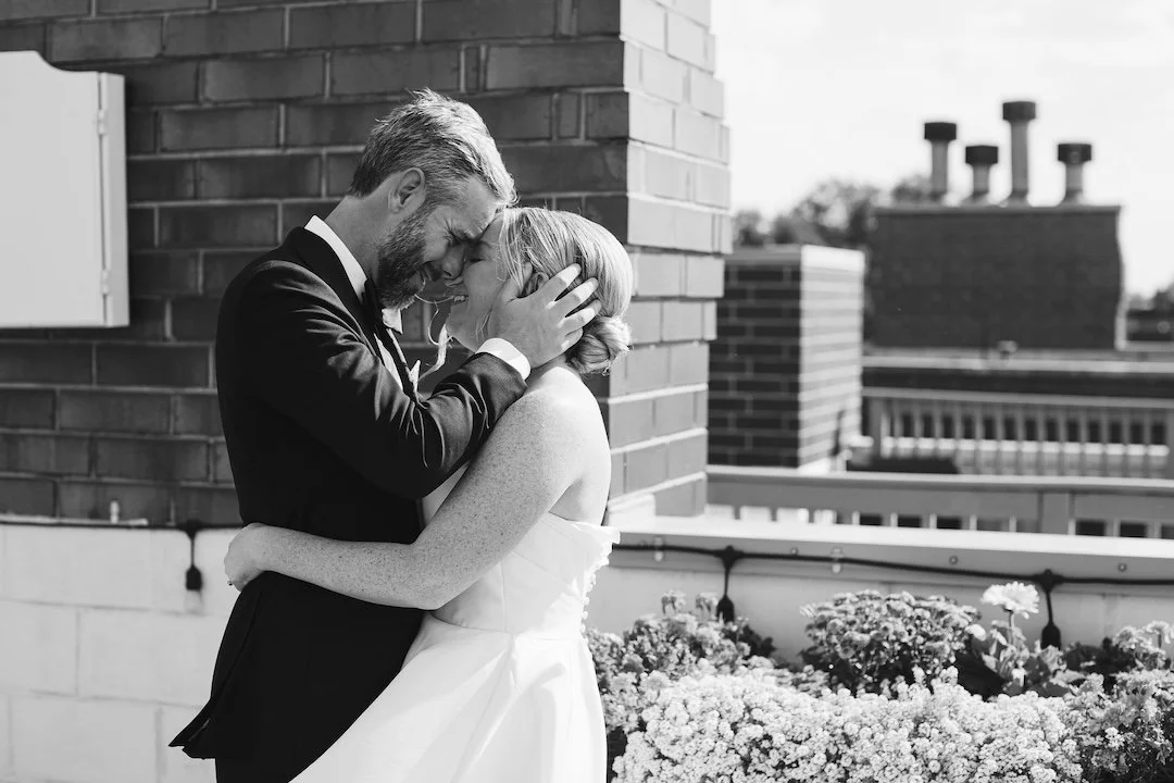 bride and groom clutch each other during their first look on a rooftop in downtown chicago