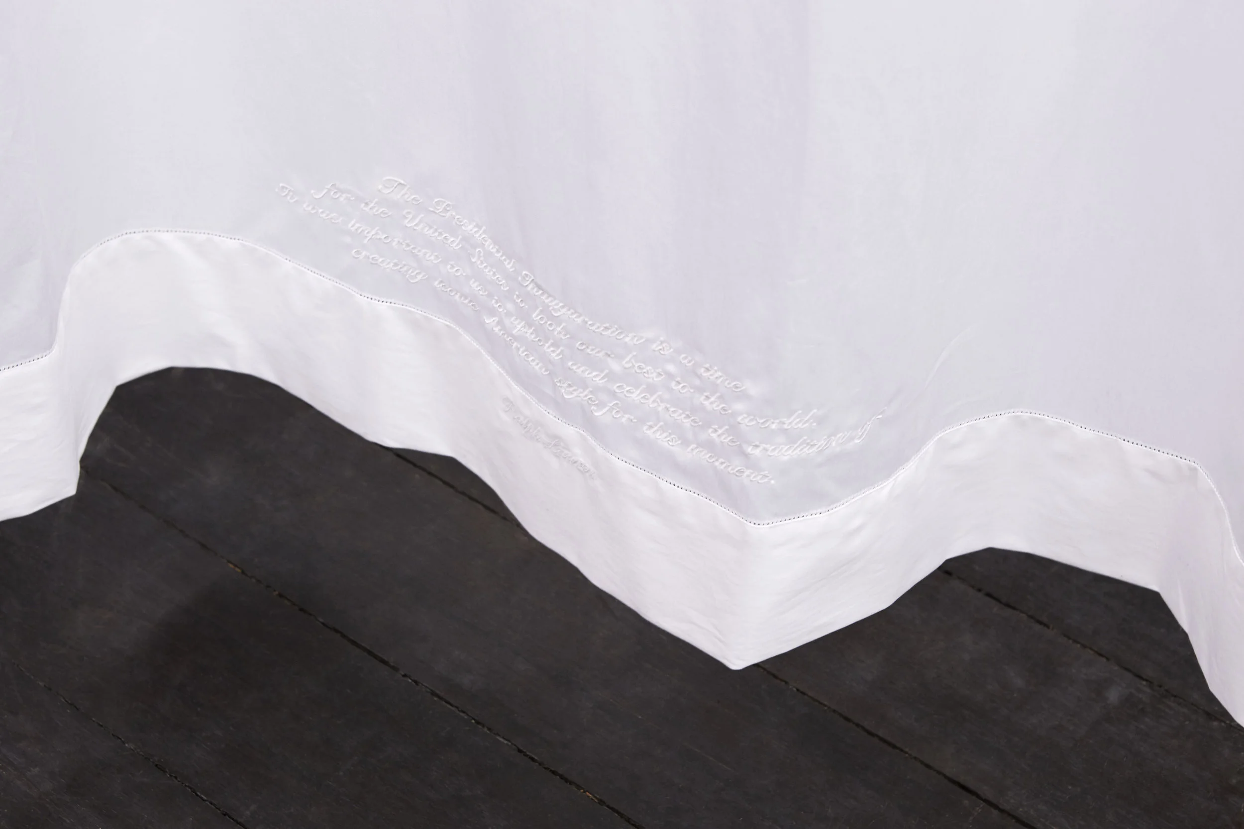 RALPH LAUREN HOME , 2017, embroidered Ralph Lauren Home queen-size flat sheet (embroidered text reads: The Presidential Inauguration is a time for the United States to look our best to the world. It was important to us to uphold and celebrate the tradition of creating iconic American style for this moment. ’, chromed steel, 240 x 300 cm, installation view, Coconut Republic , Firstdraft, Sydney. Photo: Zan Wimberley. Copyright JD Reforma