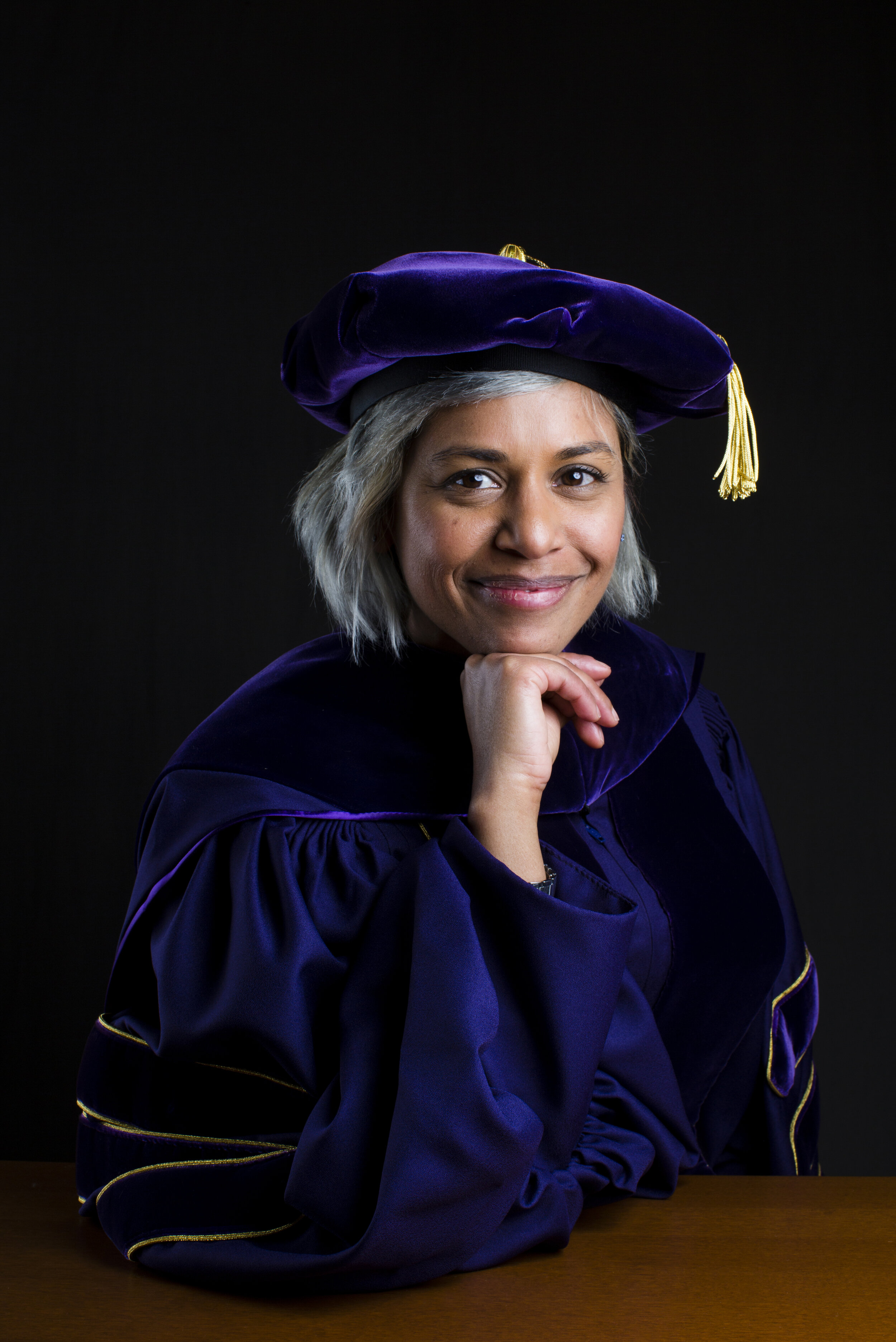  Associate Professor of Psychology Ayanna Thomas is photographed here wearing the regalia of the University of Washington, where she earned her PhD. Graduation isn’t the only time that Thomas throws on her Commencement gear, however. “I like to wear 