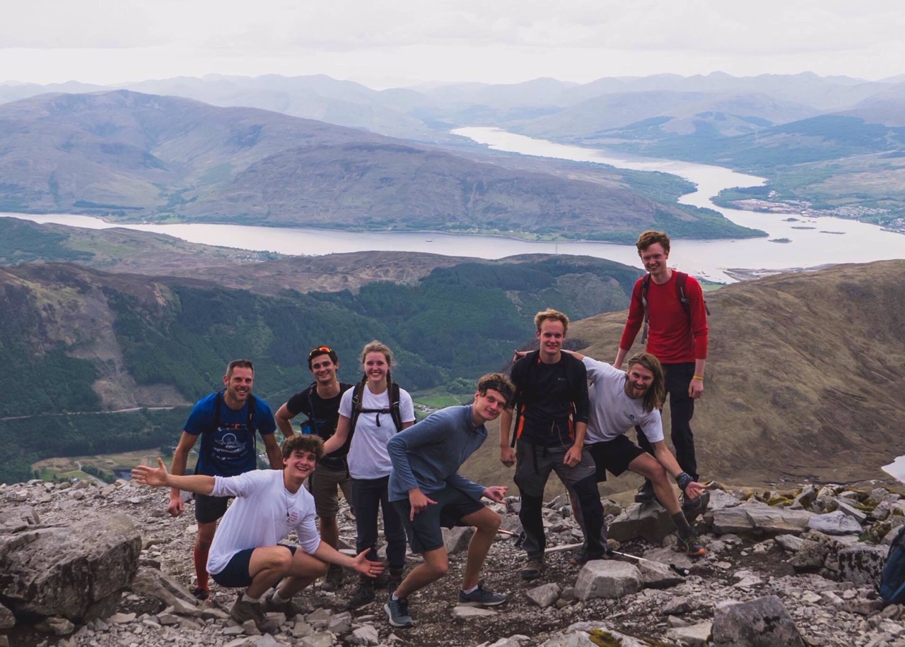 An image of Jago and a group of friends in a beautiful mountain region (with lakes in the background)
