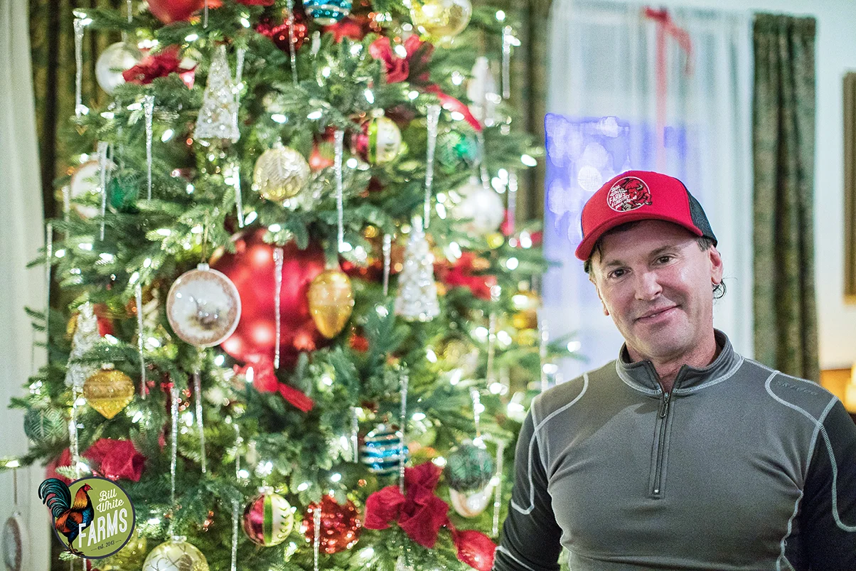 Bill White stands next to the Farms' Christmas tree. 
