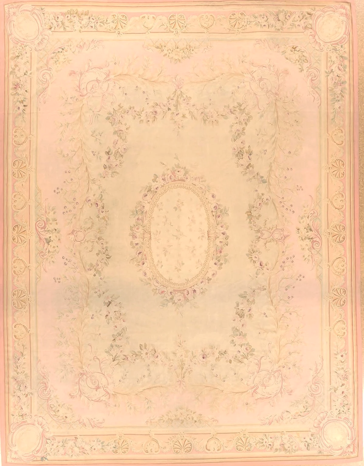 An elegant, pastel-colored area rug with floral and ornate patterns, featuring a central oval design surrounded by intricate border details in shades of pink, cream, and light green.
