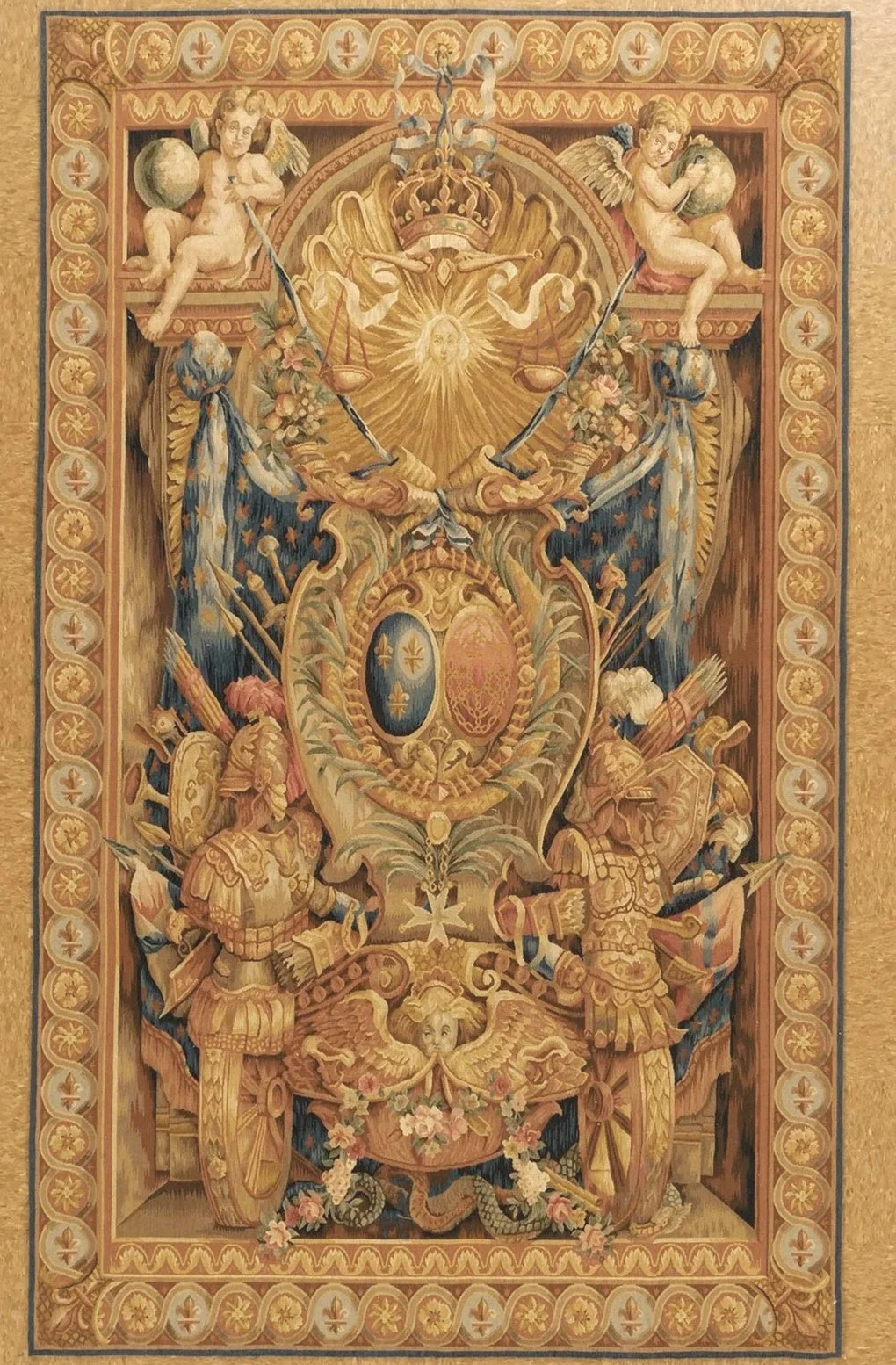A detailed tapestry featuring heraldic symbols, armor, banners, and cherubs, with a symmetrical, ornate design and a decorative border.