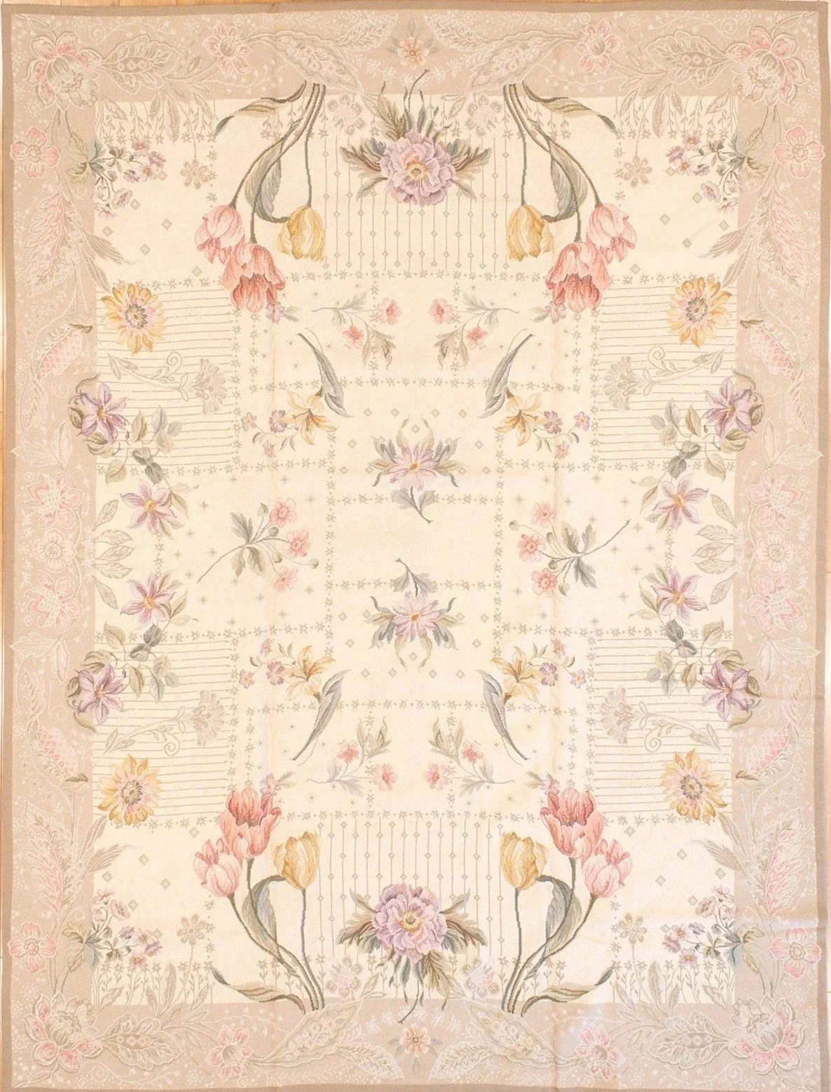 A pastel-colored Heavy needlepoint hand woven floral patterned rug with various flowers and leaves arranged symmetrically.