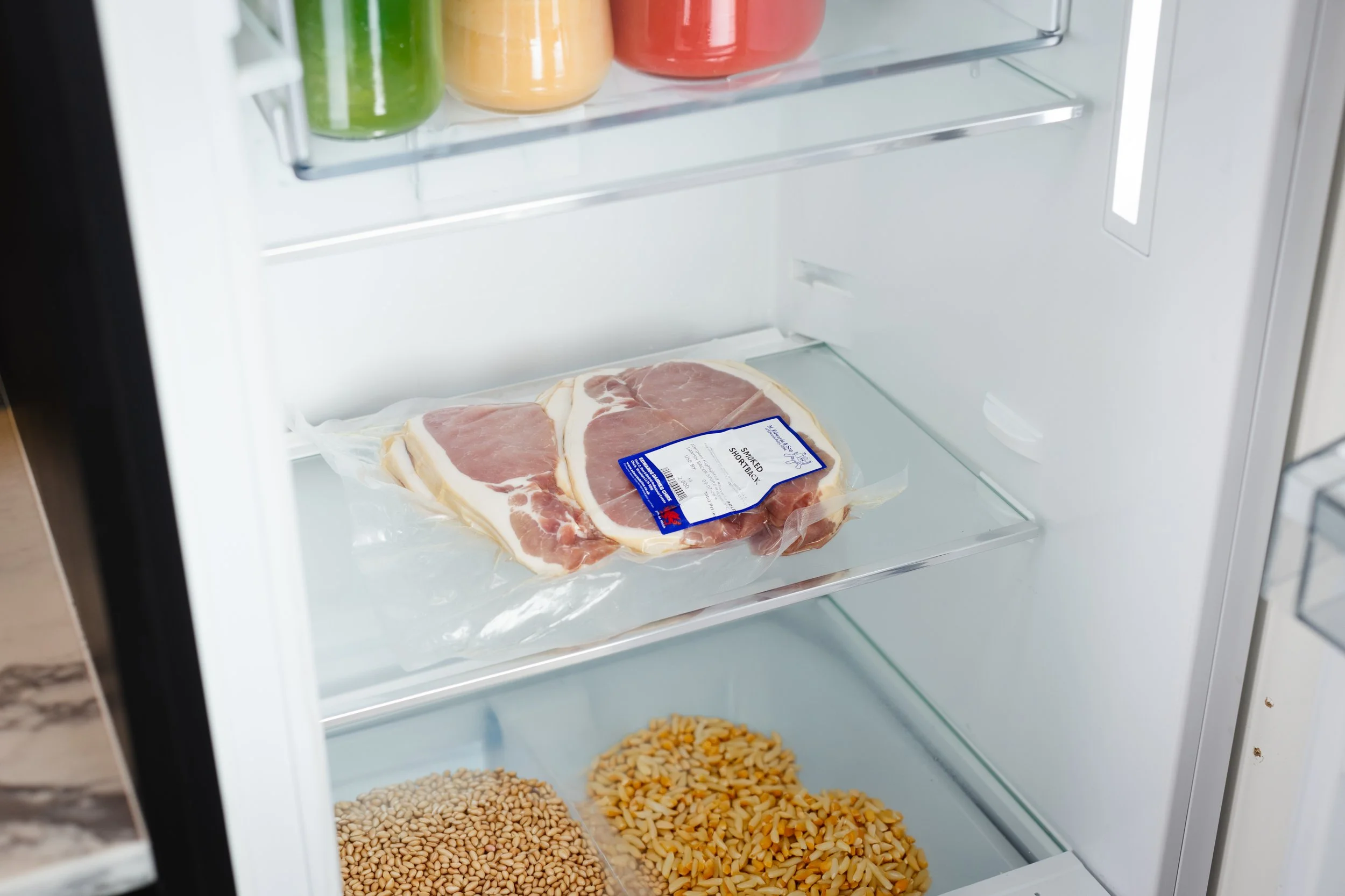 Packaged bacon or ham in fridge.  Commercial photography.
